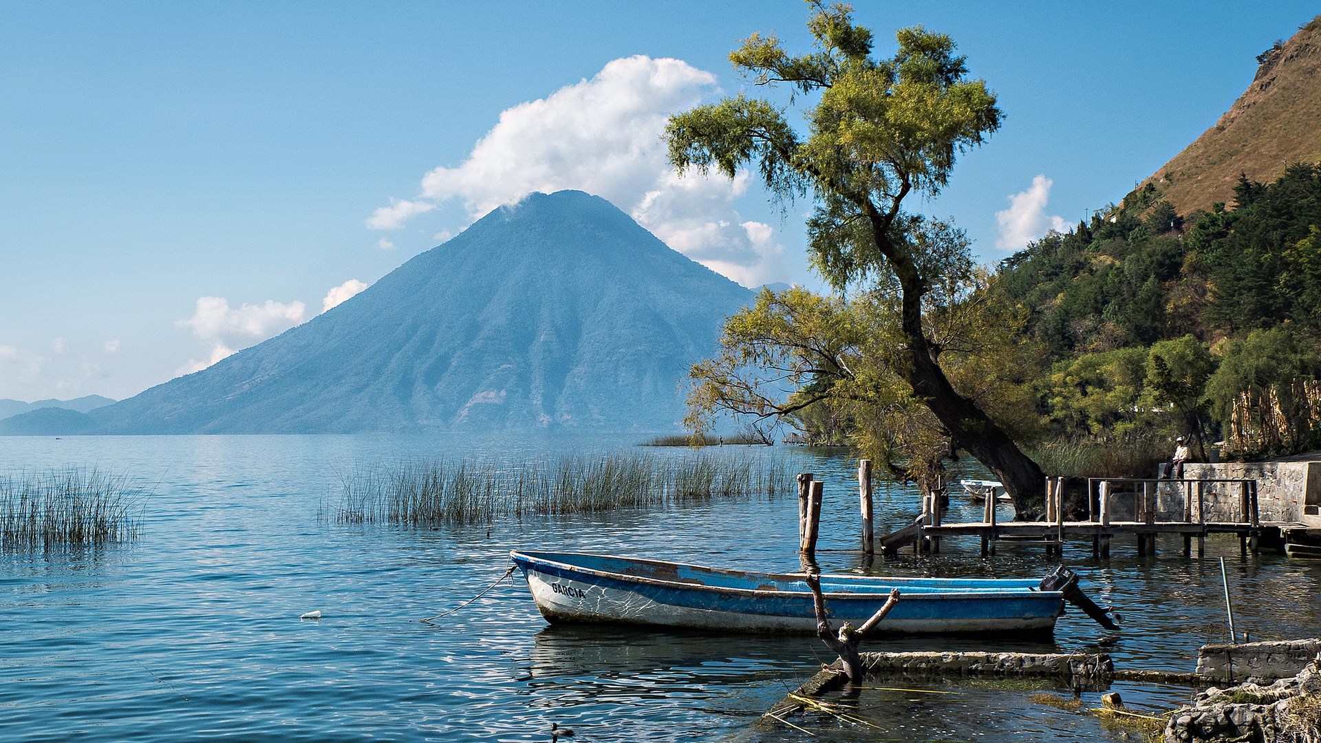 Volcano and lake with a boat and pier HD Wallpaper