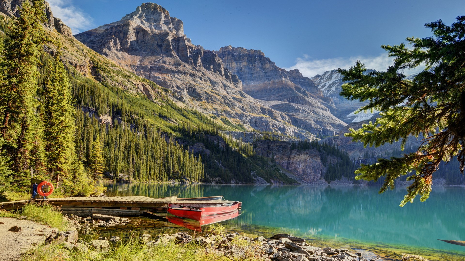 Red canoe on a wooden dock by a mountain lake HD Wallpaper
