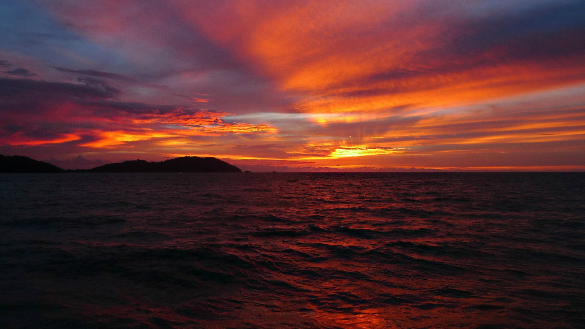 Sunset over the ocean with islands HD Wallpaper