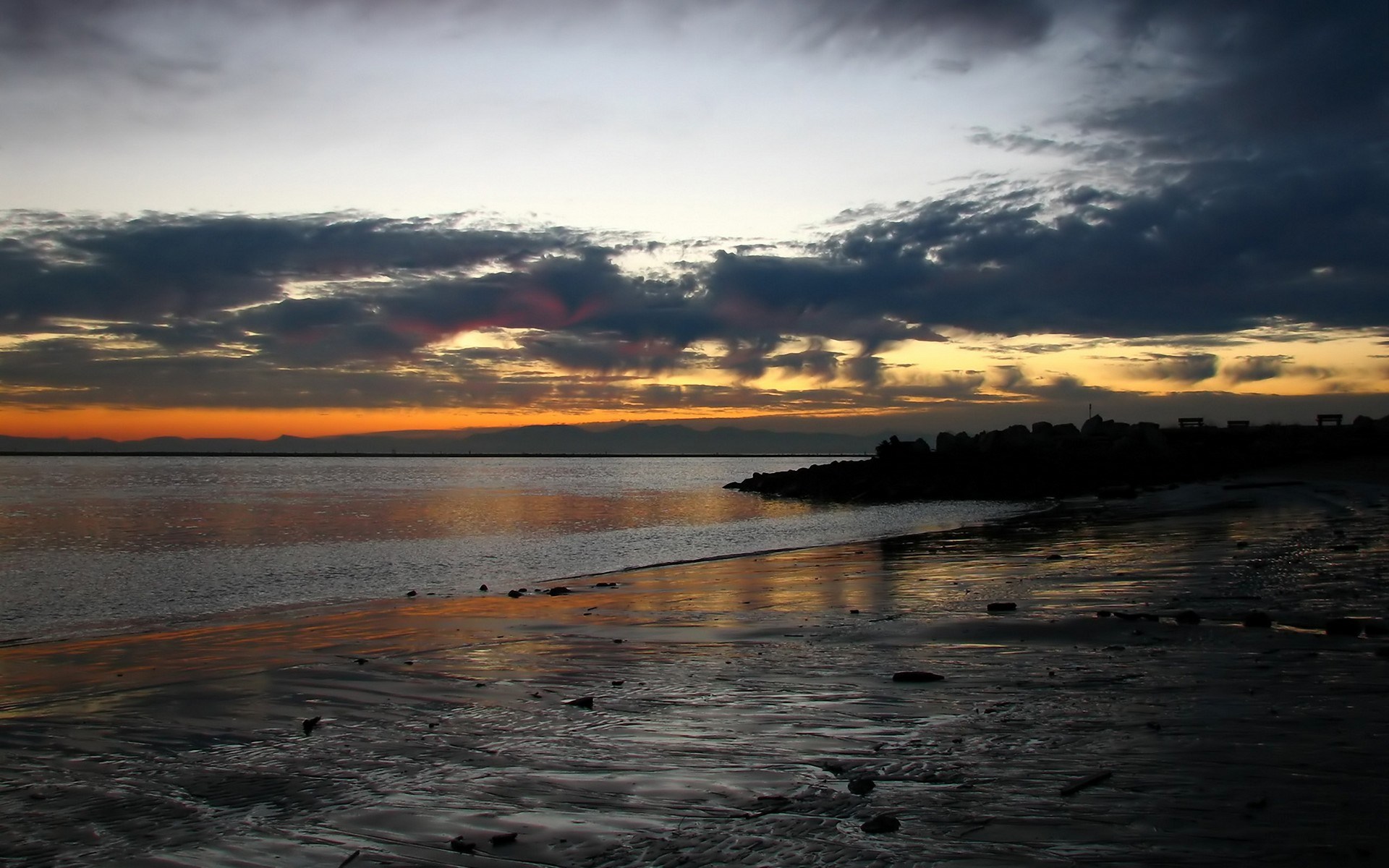 Sunset over a rocky beach with calm water HD Wallpaper