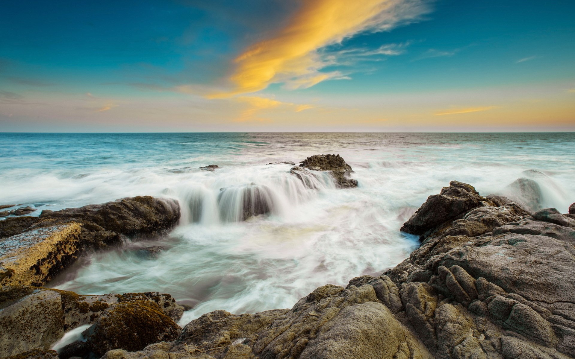 Ocean waves crashing on rocky shore at sunset HD Wallpaper