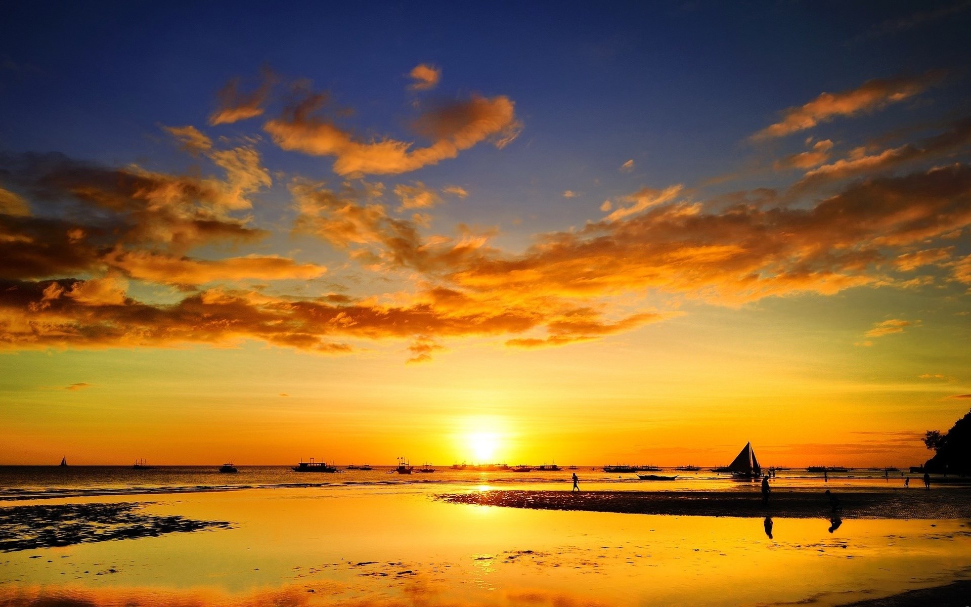 Sunset over a beach with boats and people HD Wallpaper