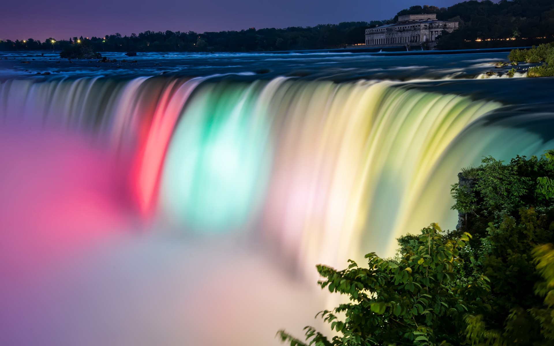 Niagara Falls illuminated with colorful lights at night HD Wallpaper