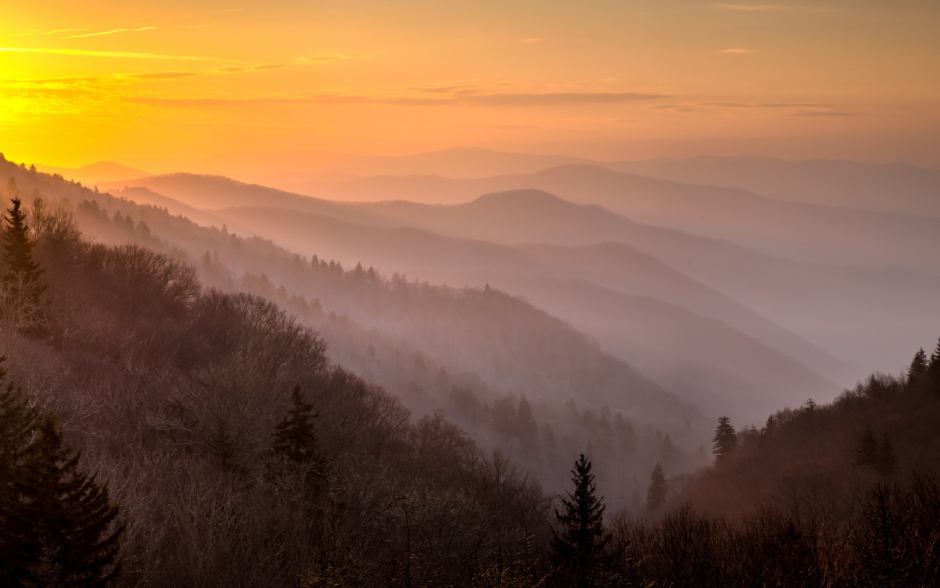 Mountain range at sunset with orange sky HD Wallpaper