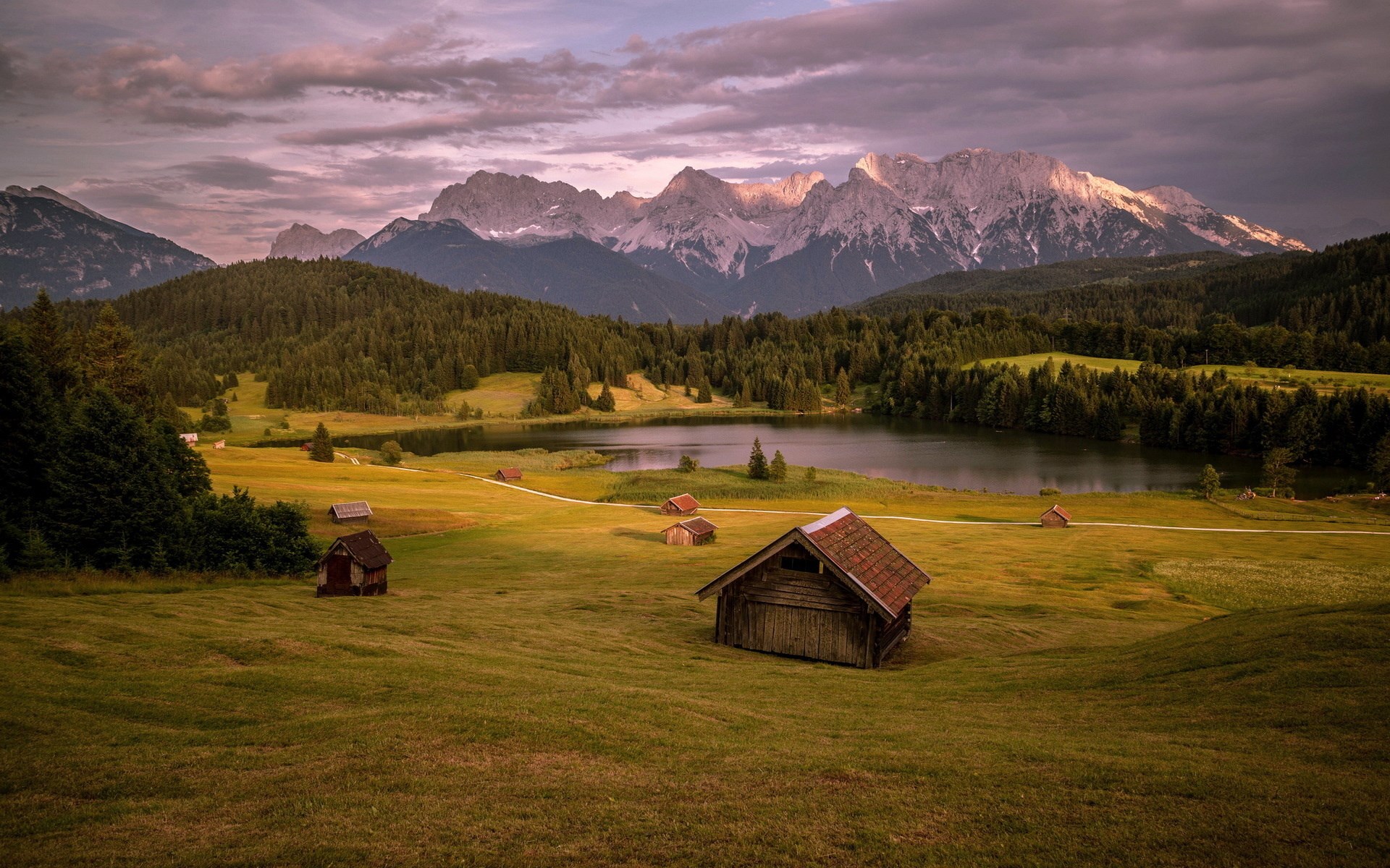 Wooden cabins by a lake with mountains in the background HD Wallpaper