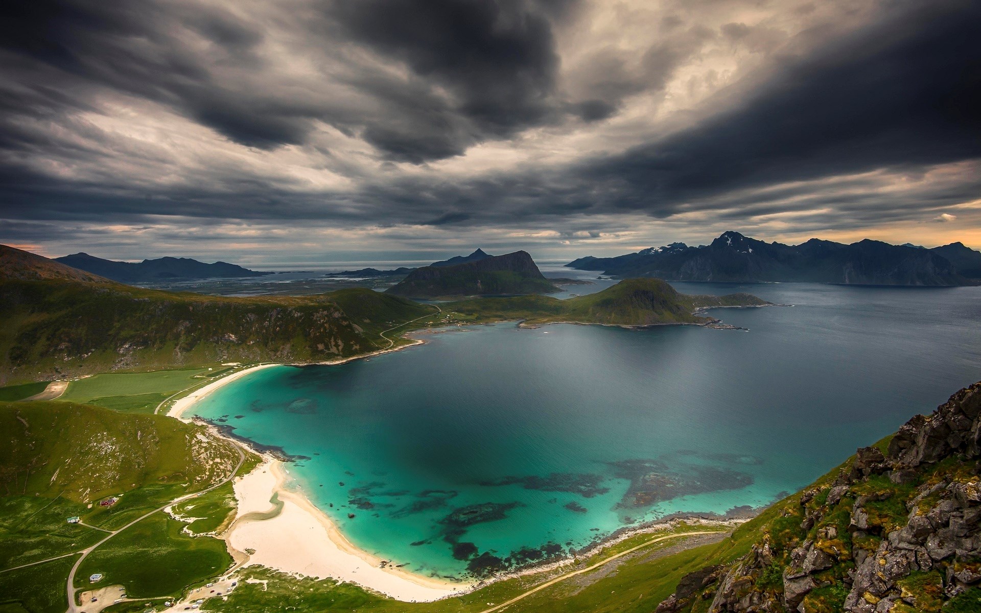 Dramatic cloudy sky over a Norwegian fjord and beach HD Wallpaper