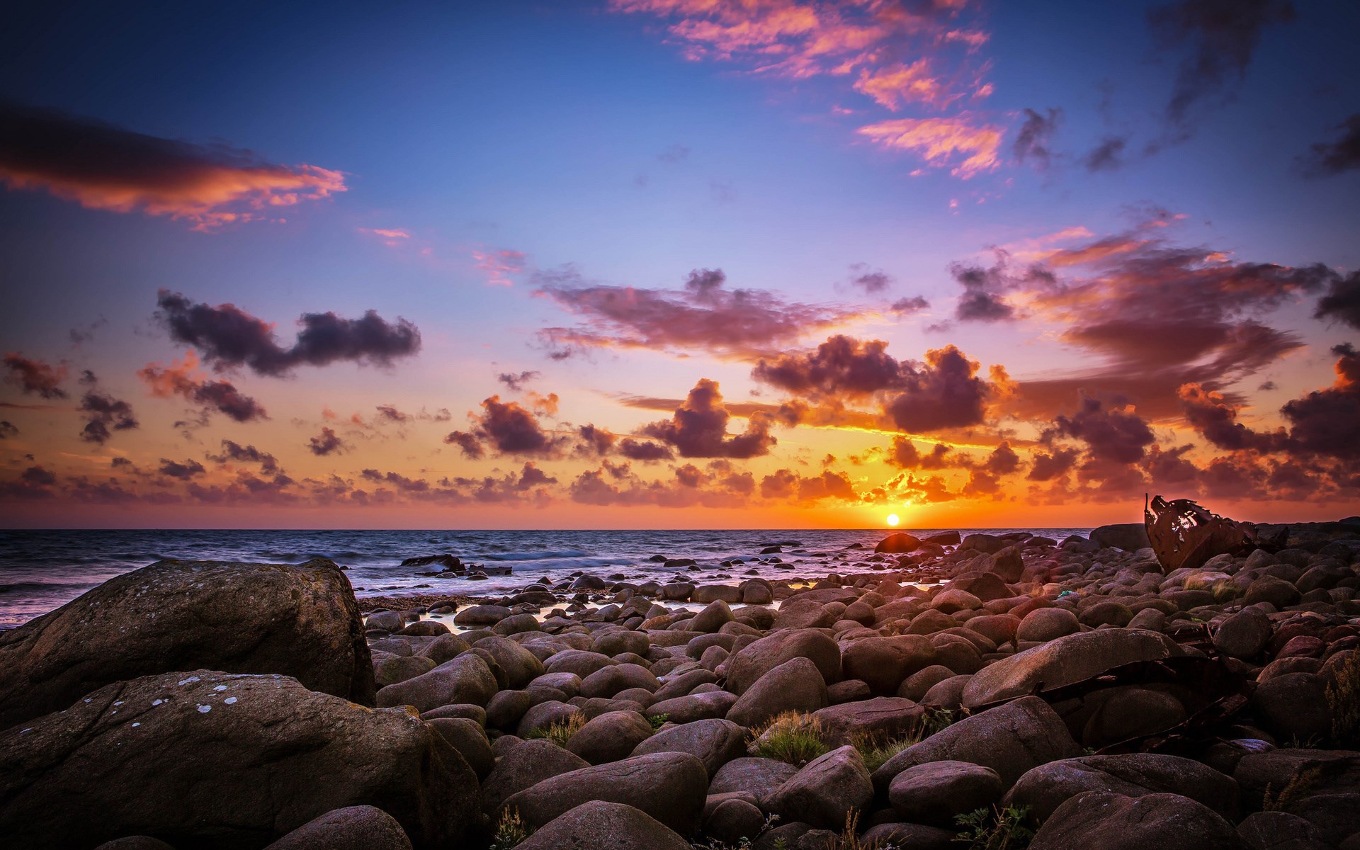 Sunset over rocky beach with shipwreck HD Wallpaper