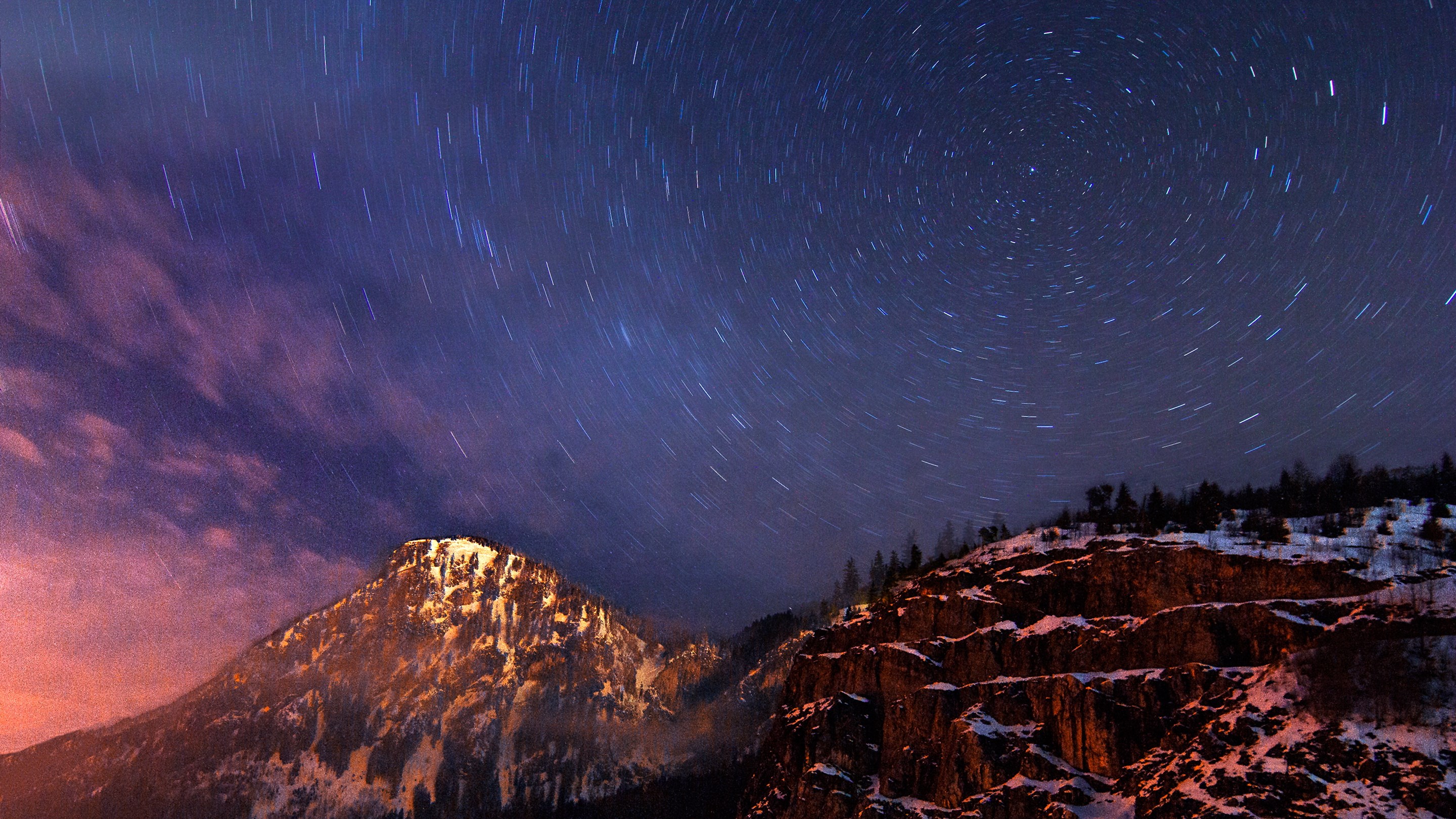 Star trails over snow-covered mountains at night HD Wallpaper
