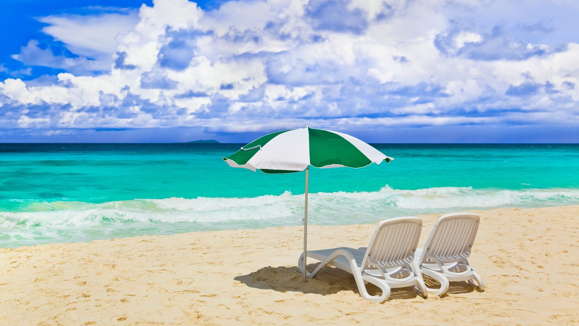 Beach chairs and umbrella on a sandy beach with ocean HD Wallpaper