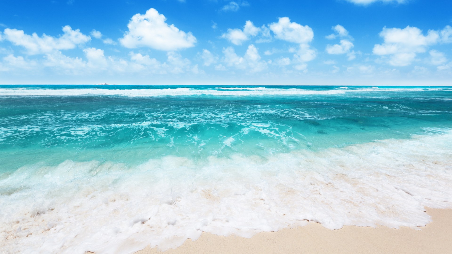 Ocean waves crashing on a sandy beach under a blue sky HD Wallpaper