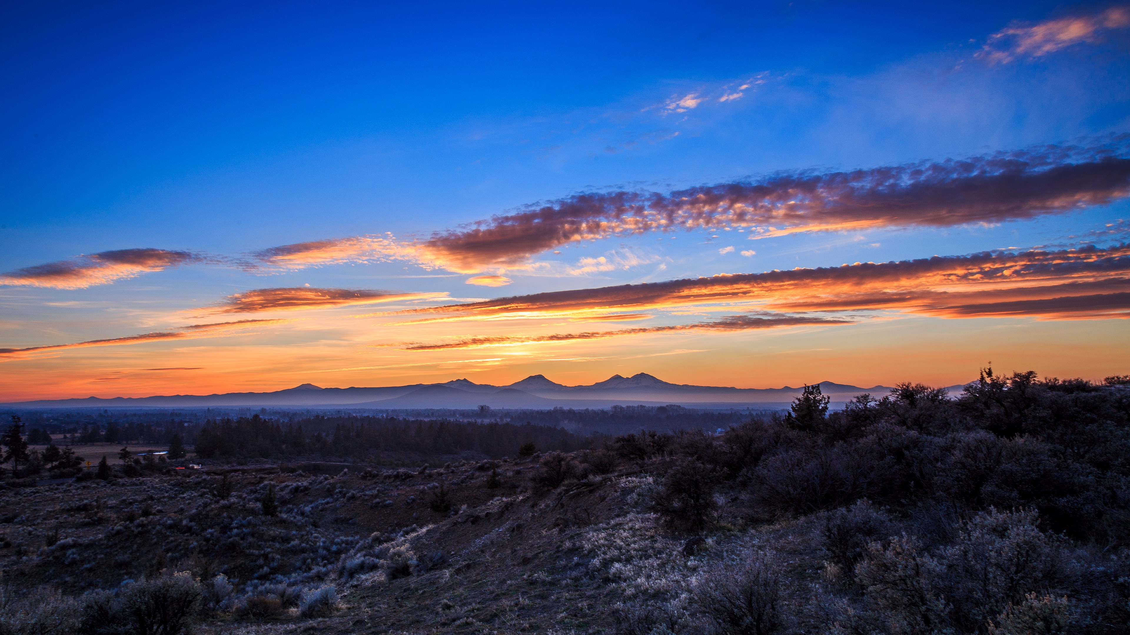Sunset over a valley with mountains and clouds HD Wallpaper