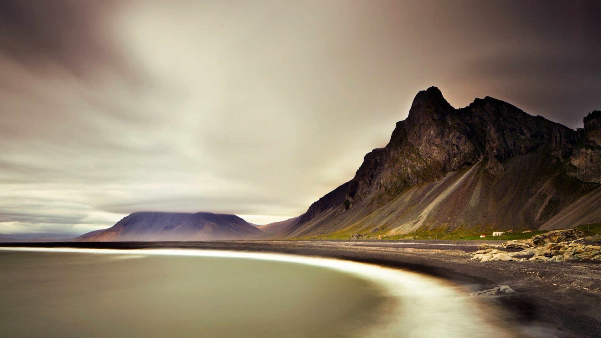 Long exposure of a rugged Icelandic coast with mountains and sea HD Wallpaper