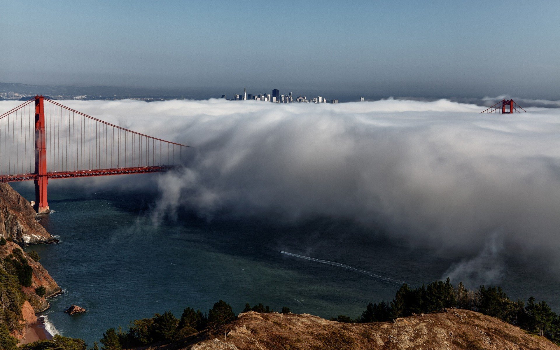 Golden Gate Bridge shrouded in fog with San Francisco skyline HD Wallpaper