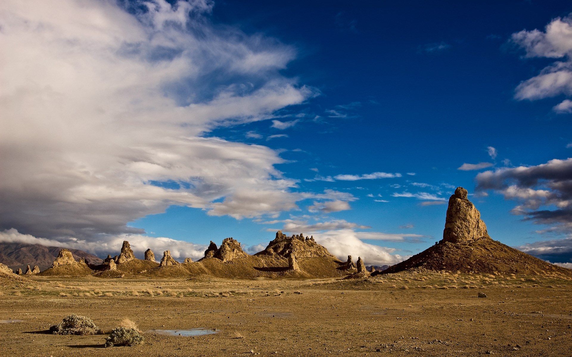Desert landscape with rock formations and clouds HD Wallpaper