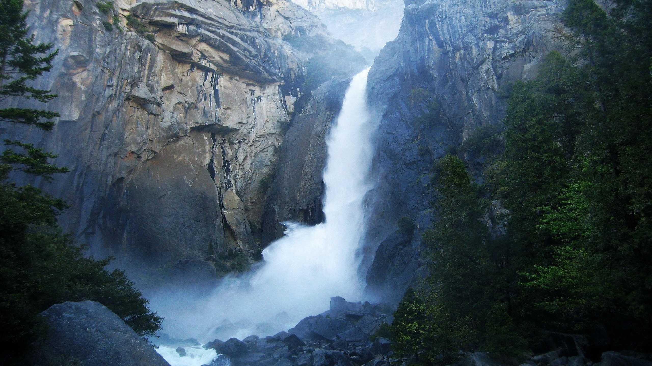 Waterfall cascading down a rocky cliff face HD Wallpaper