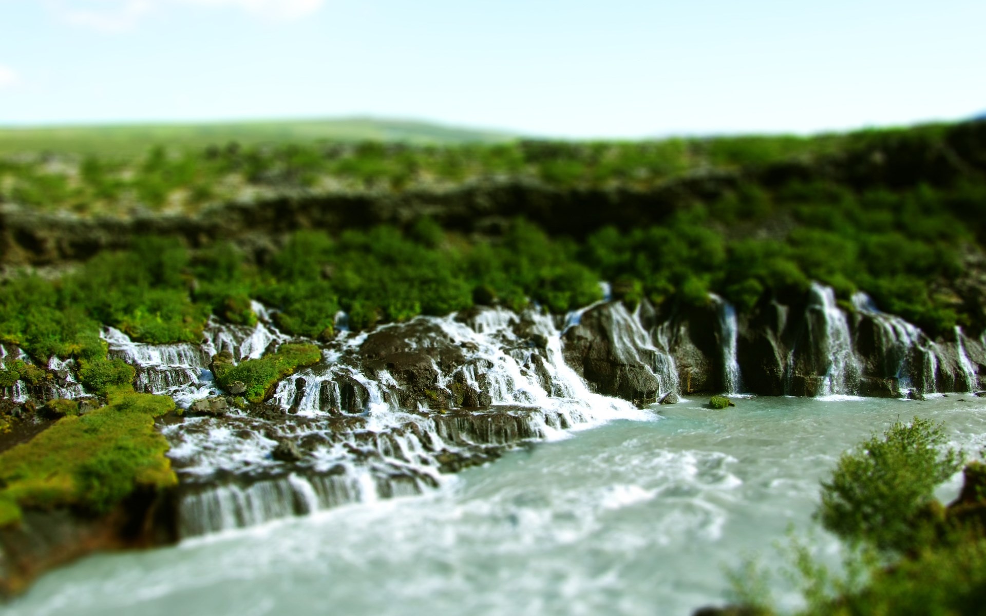 Waterfalls cascading over mossy rocks into a river HD Wallpaper