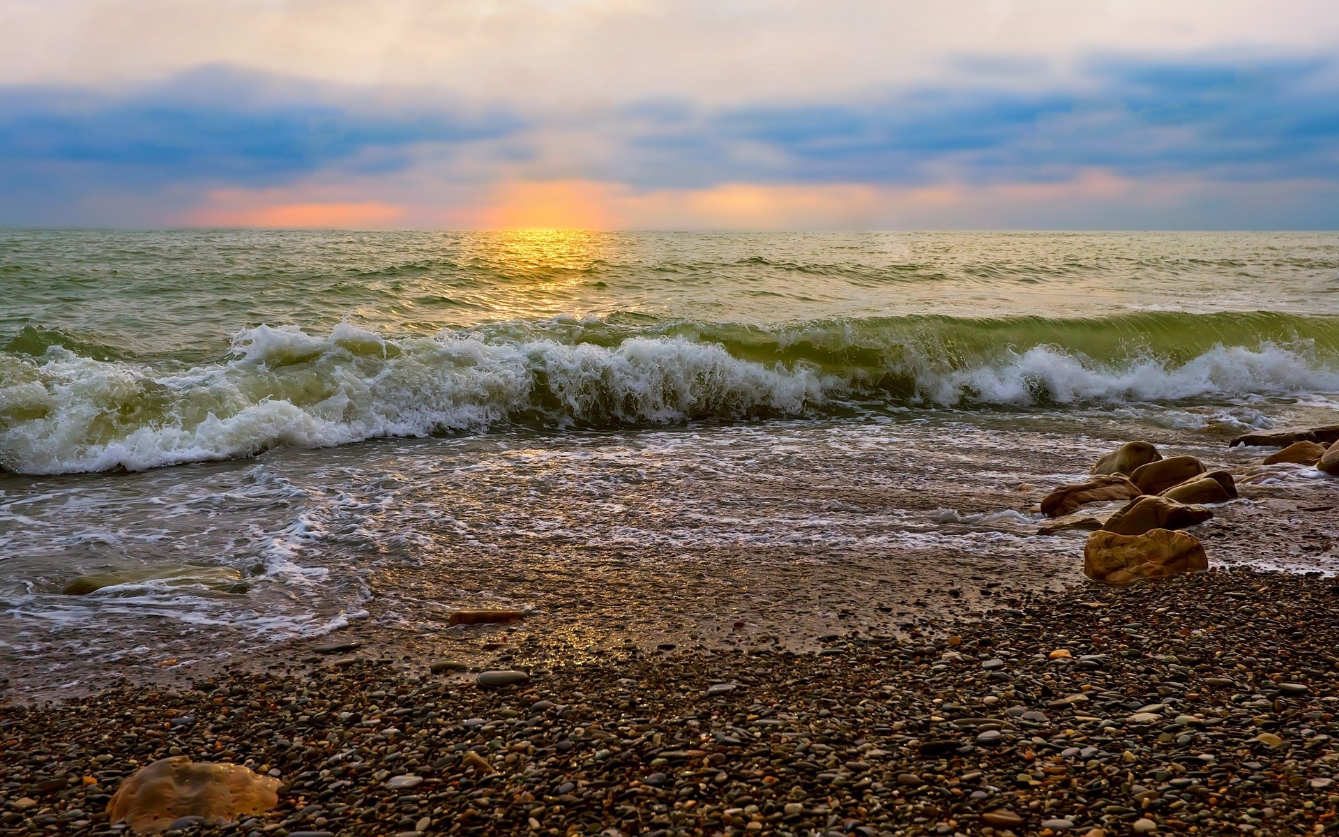 Waves crashing on a pebble beach at sunset HD Wallpaper