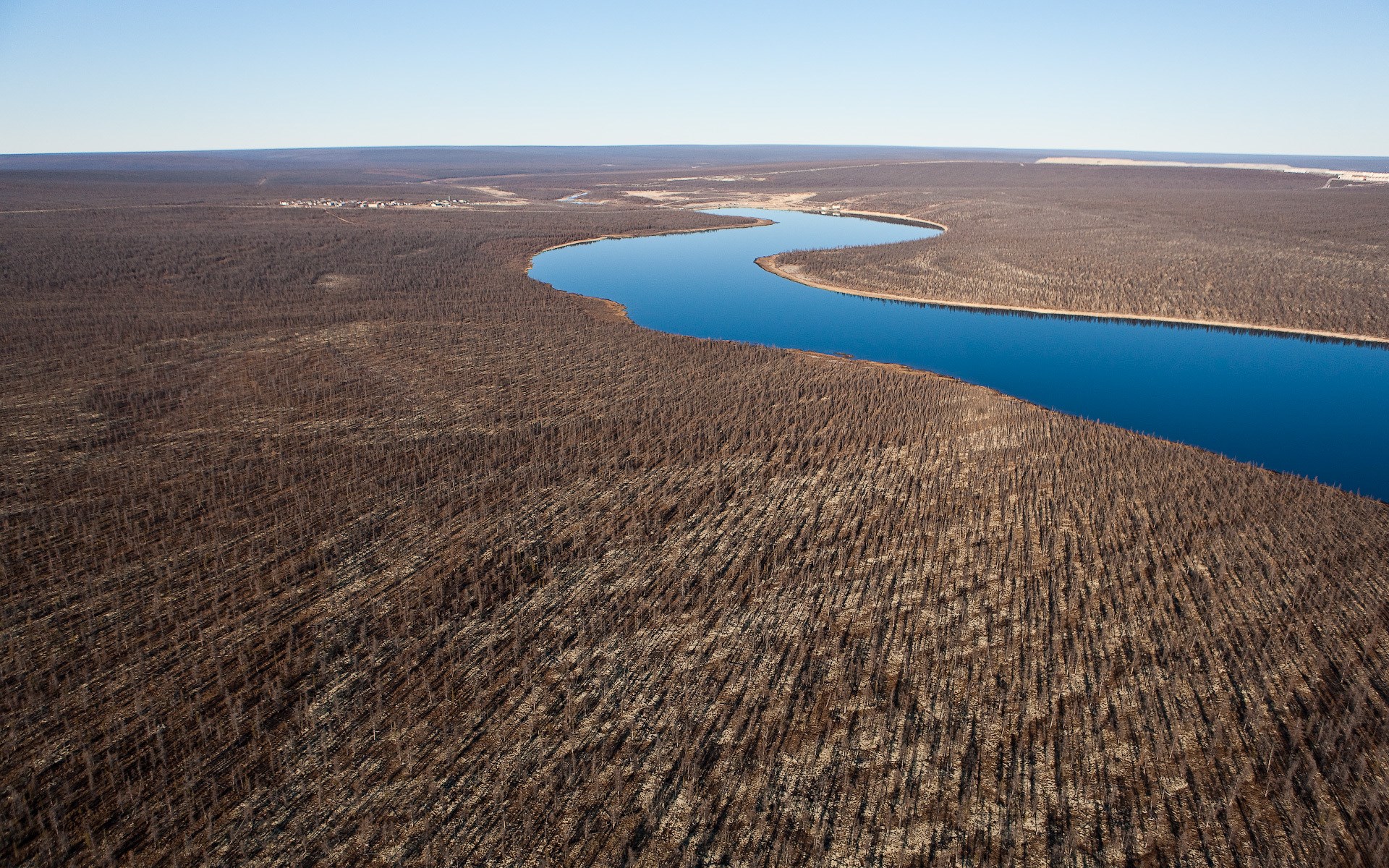 Aerial view of a winding river through a barren landscape HD Wallpaper