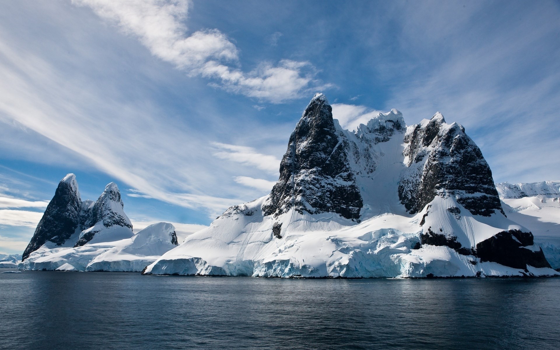 Snow-covered mountains and sea under a cloudy sky HD Wallpaper
