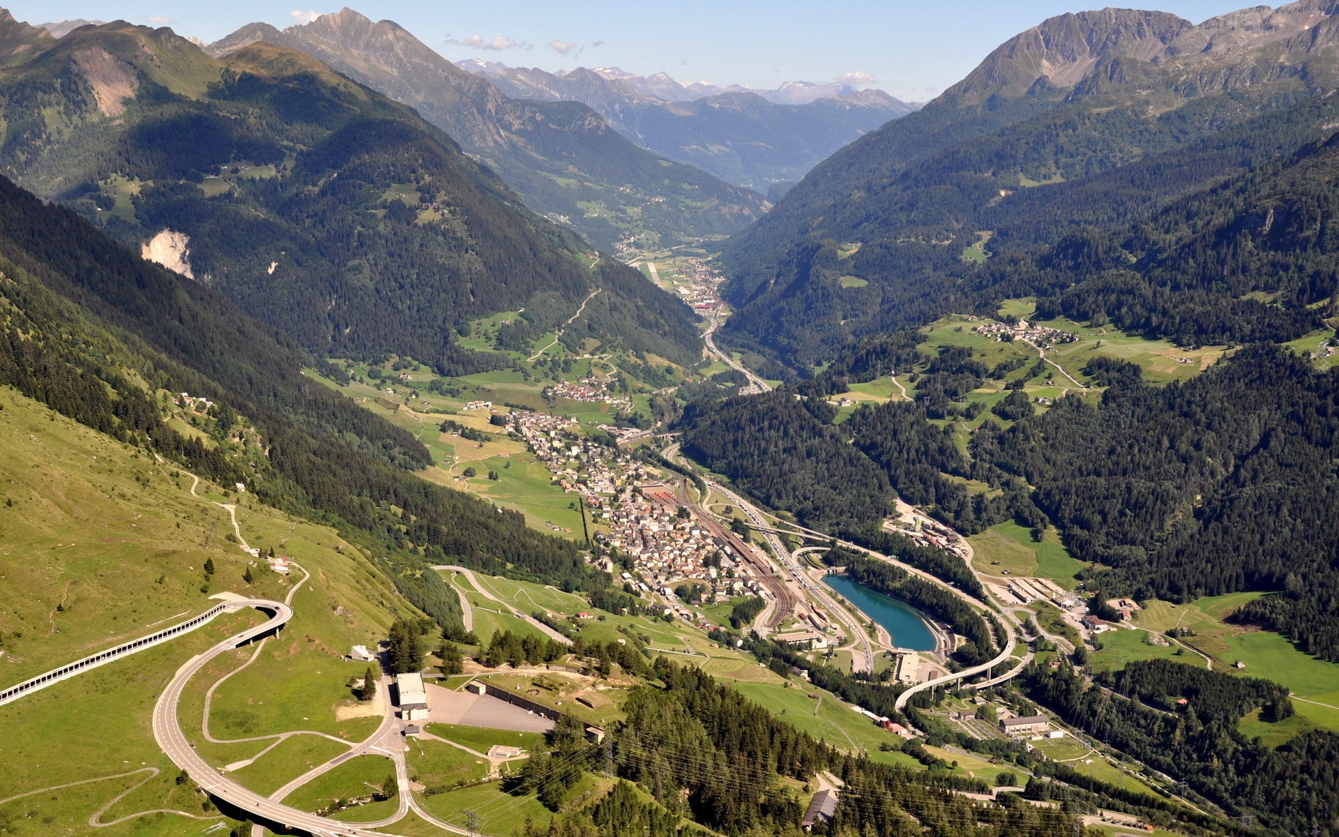 Aerial view of a mountain valley with a town and infrastructure HD Wallpaper