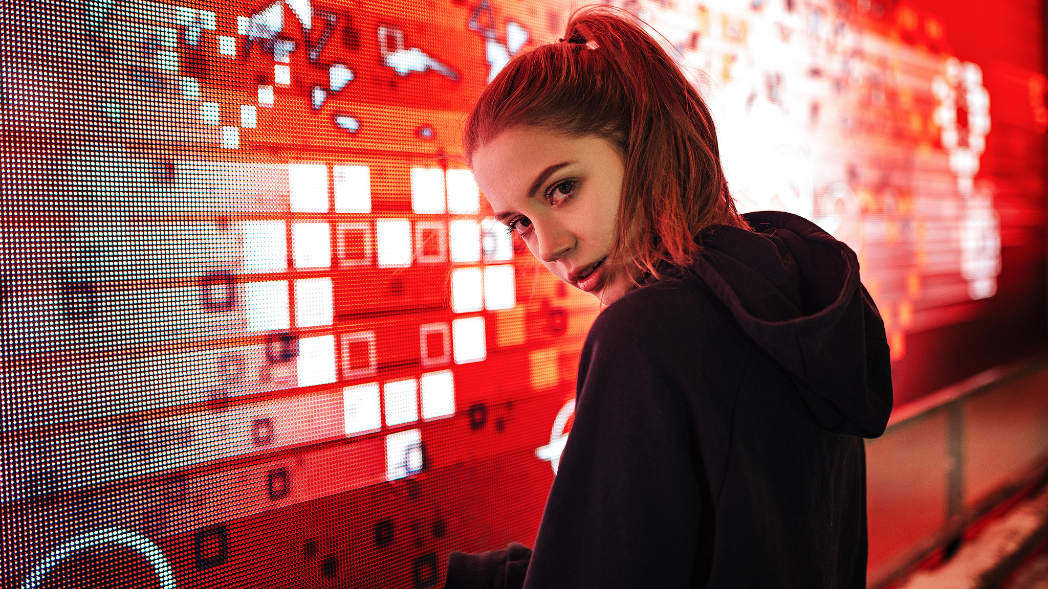 Woman with ponytail in black hoodie looking over shoulder HD Wallpaper