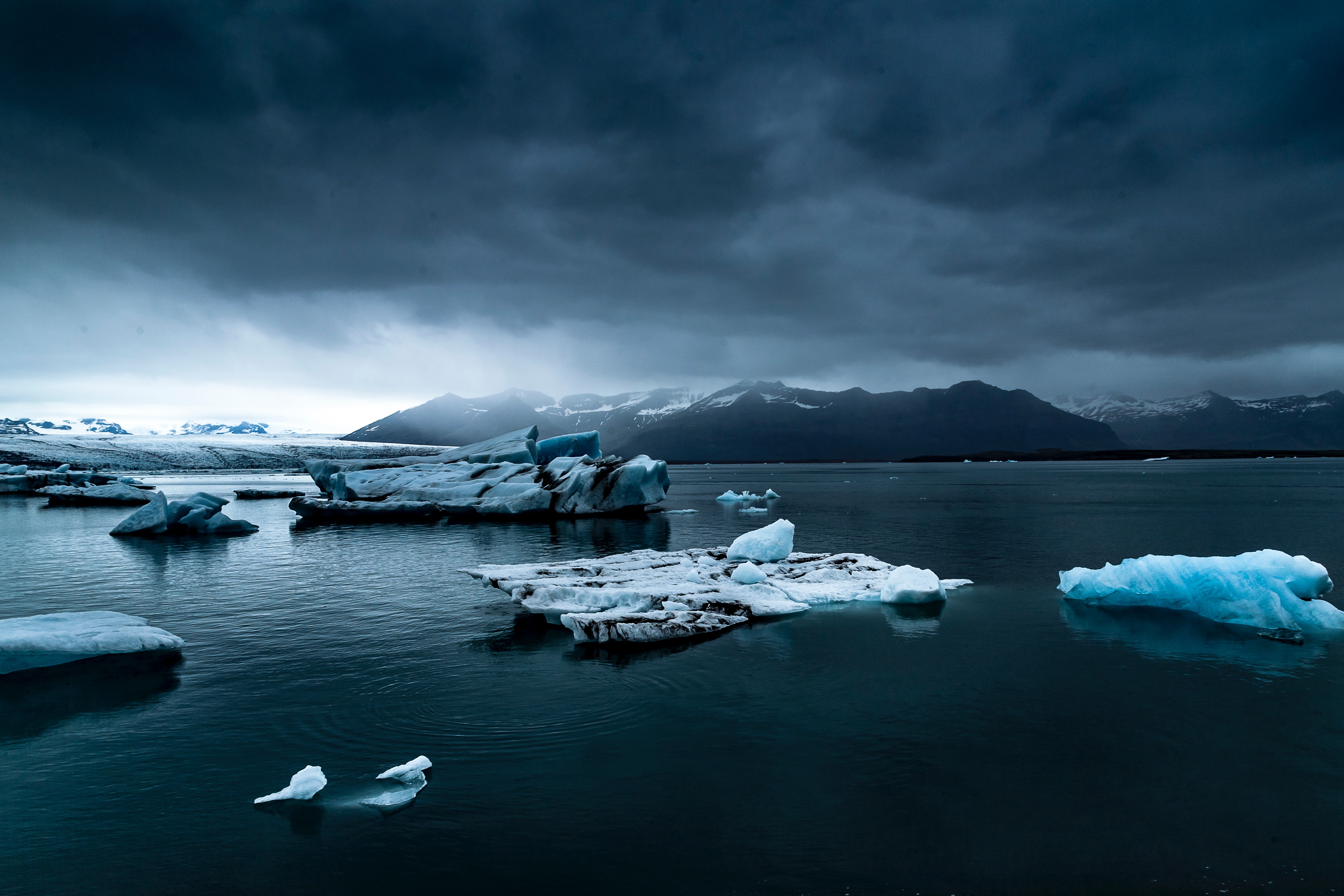 Icebergs in Jökulsárlón, Iceland under stormy clouds HD Wallpaper