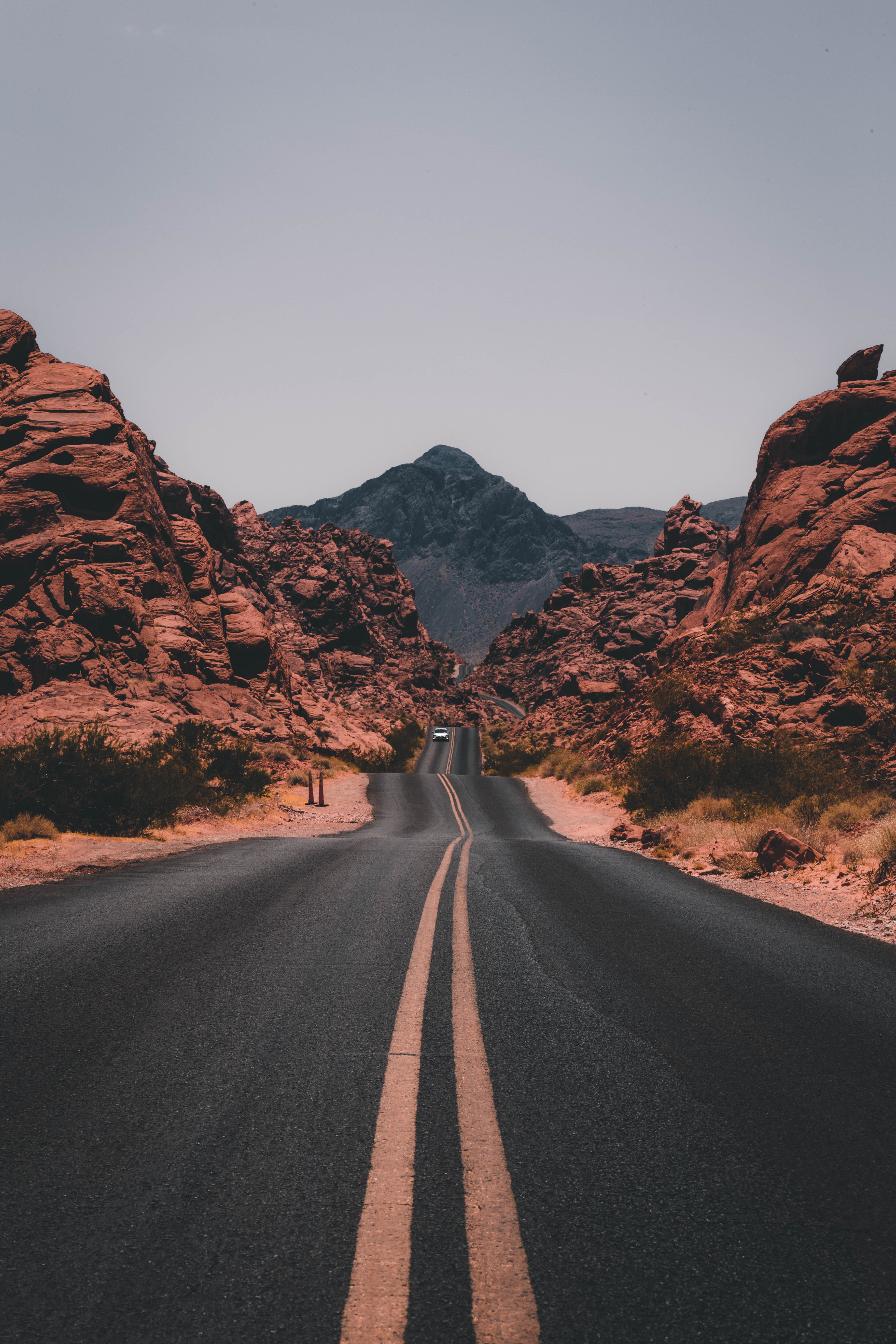 Road through Valley of Fire State Park with red rocks and mountains HD Wallpaper
