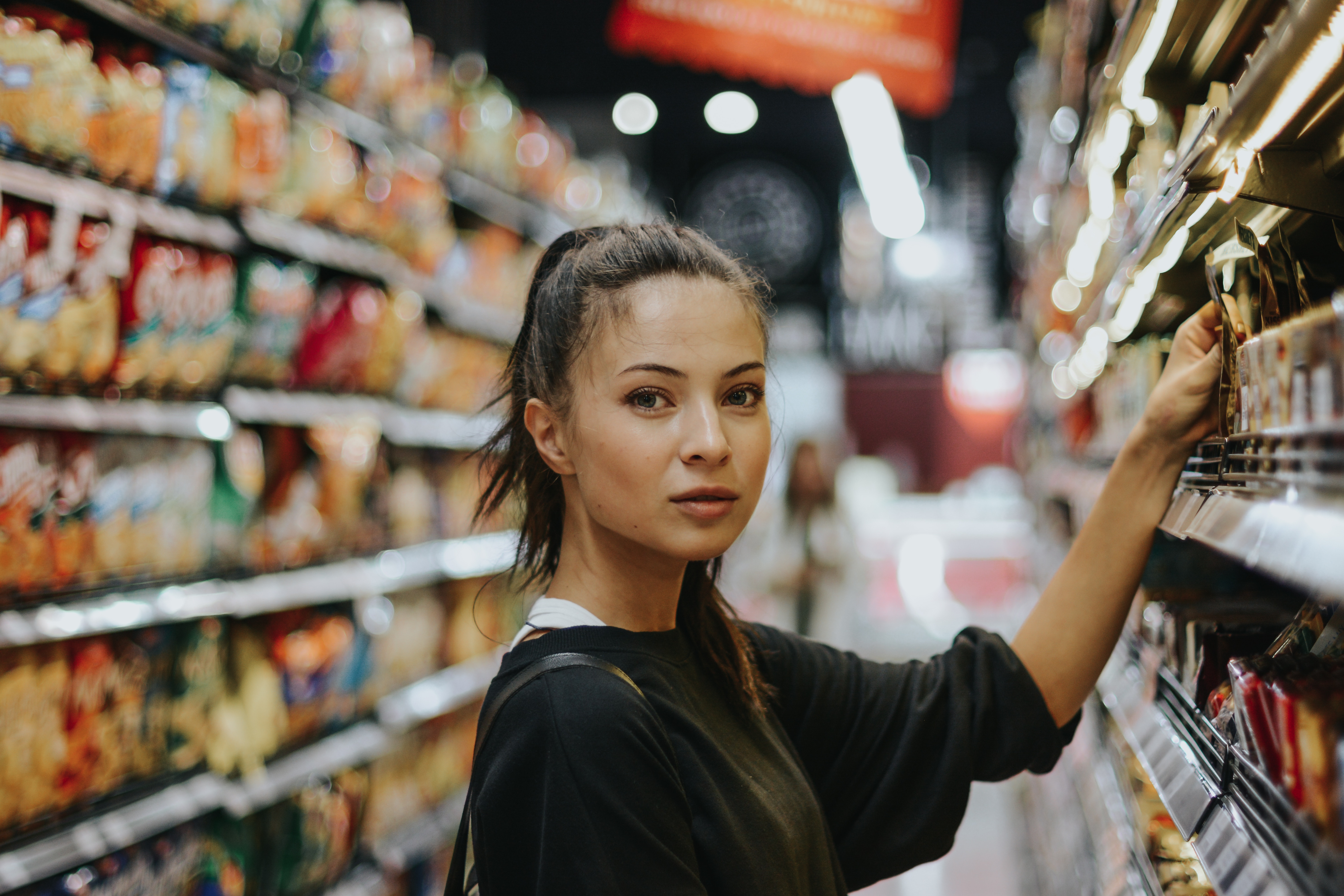 Woman shopping in a grocery store aisle HD Wallpaper
