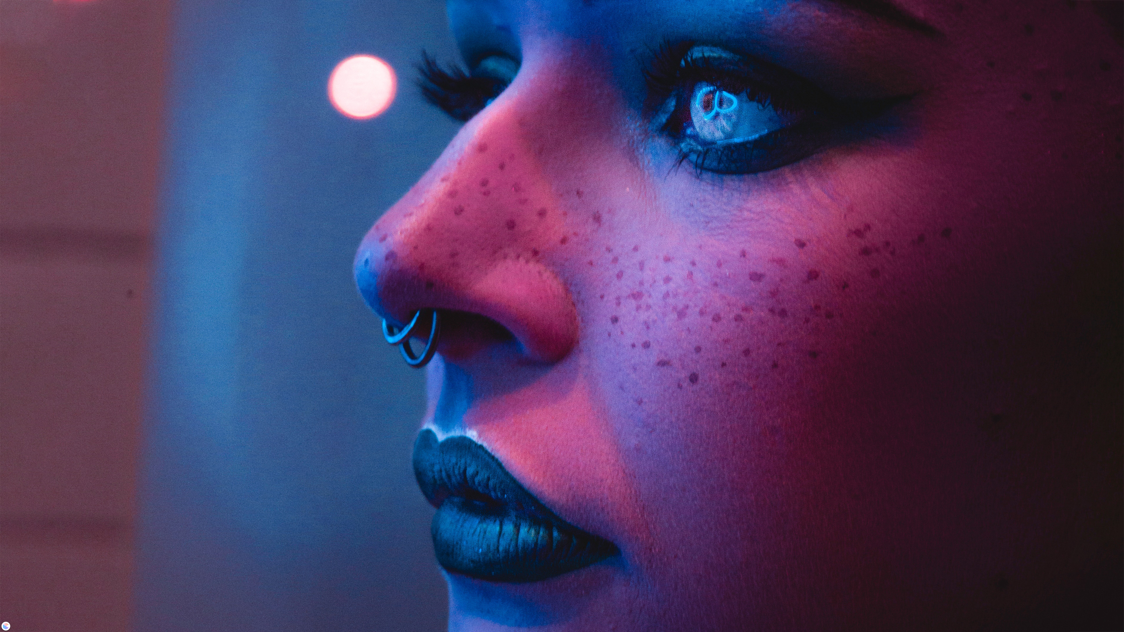 Woman with nose piercing and freckles in neon light HD Wallpaper
