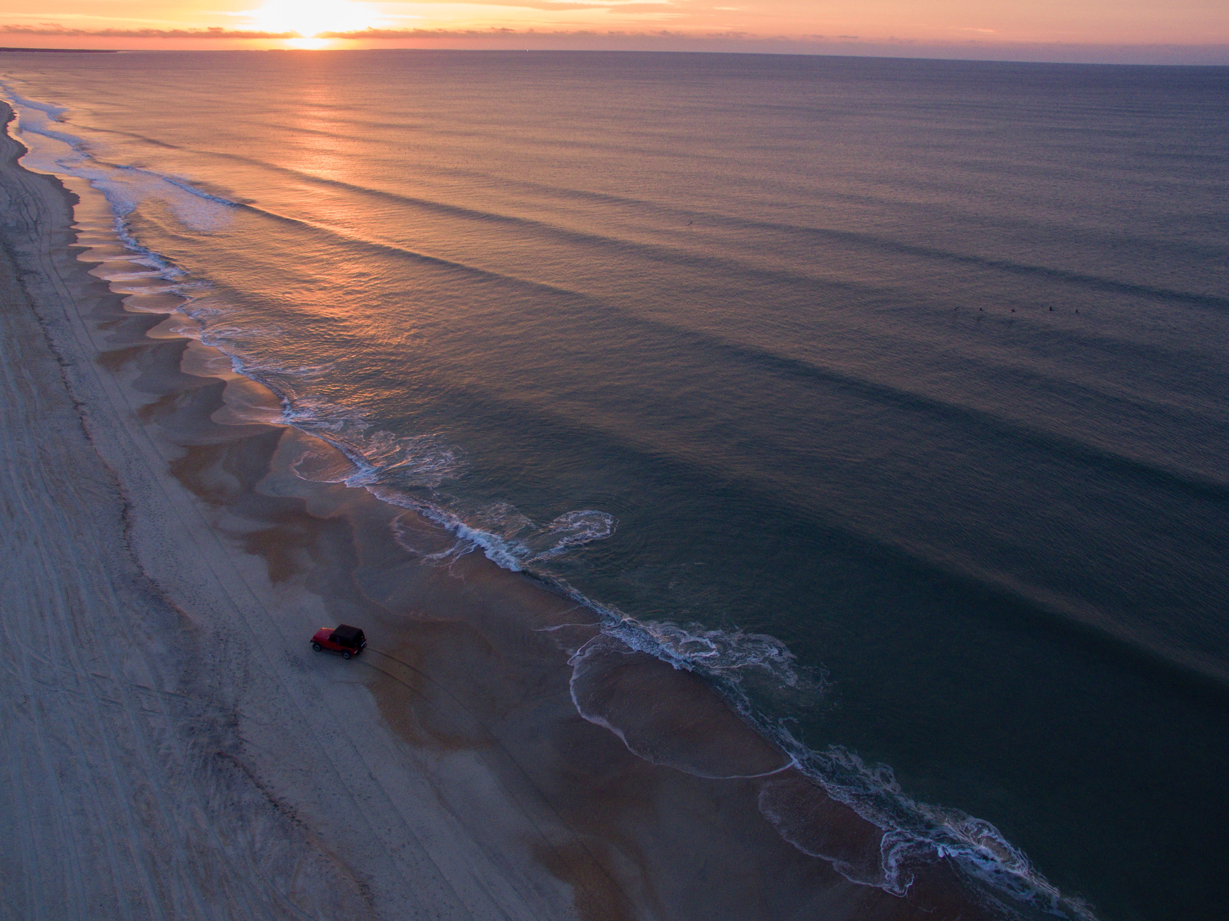 Red Jeep on a beach at sunset HD Wallpaper