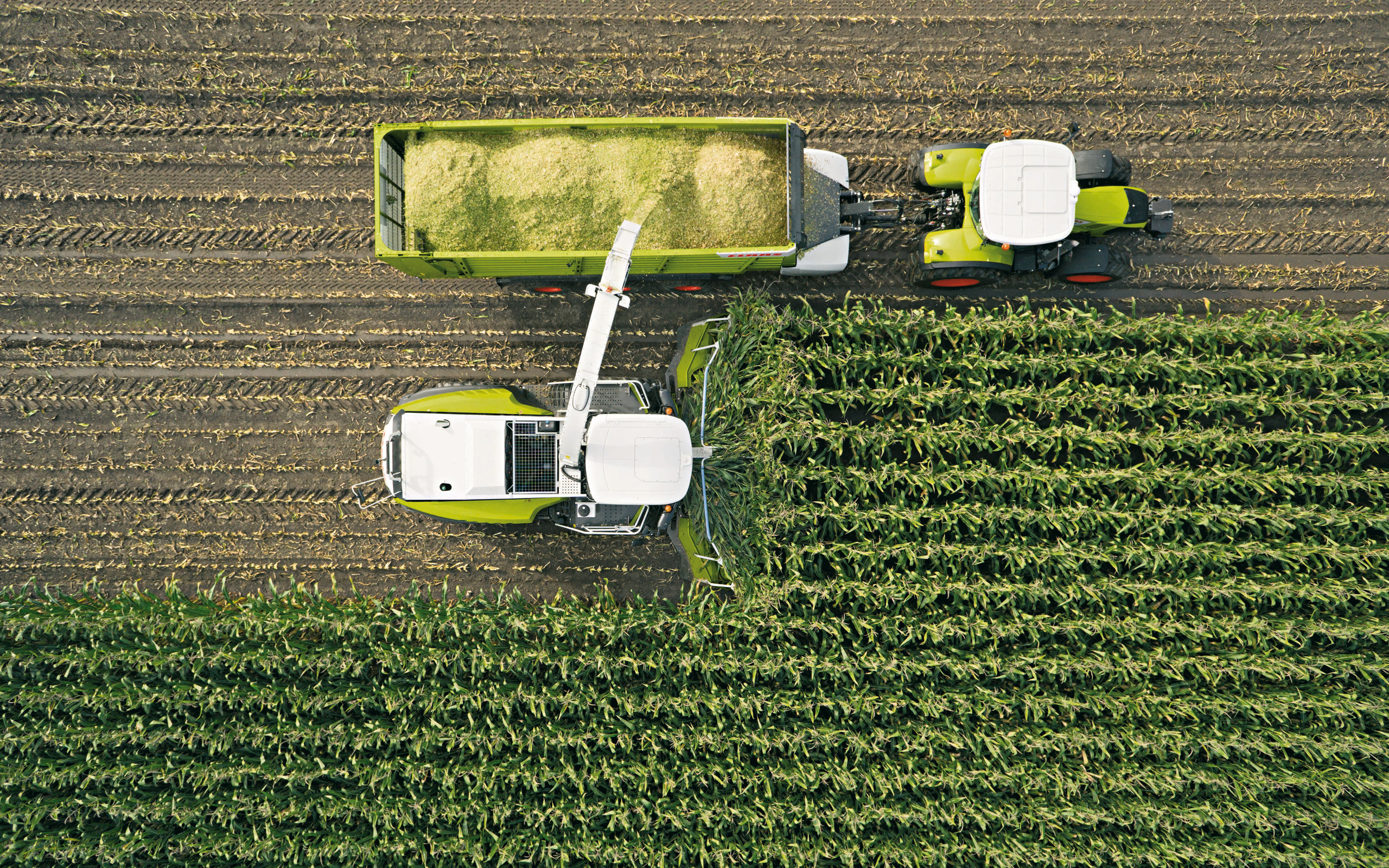 Aerial view of Claas combine harvester and tractor in a field HD Wallpaper