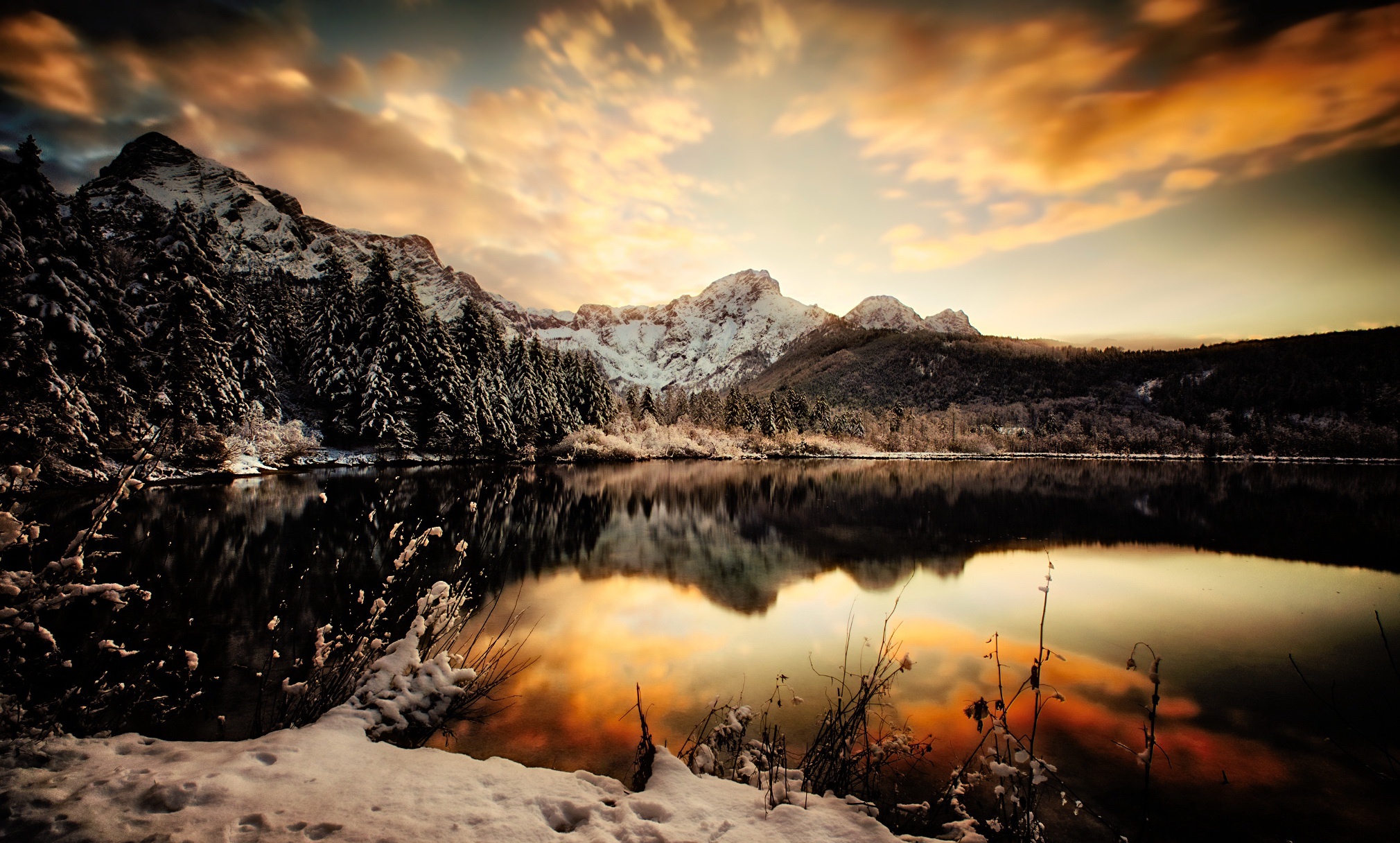 Snowy mountains reflected in a lake at sunset HD Wallpaper
