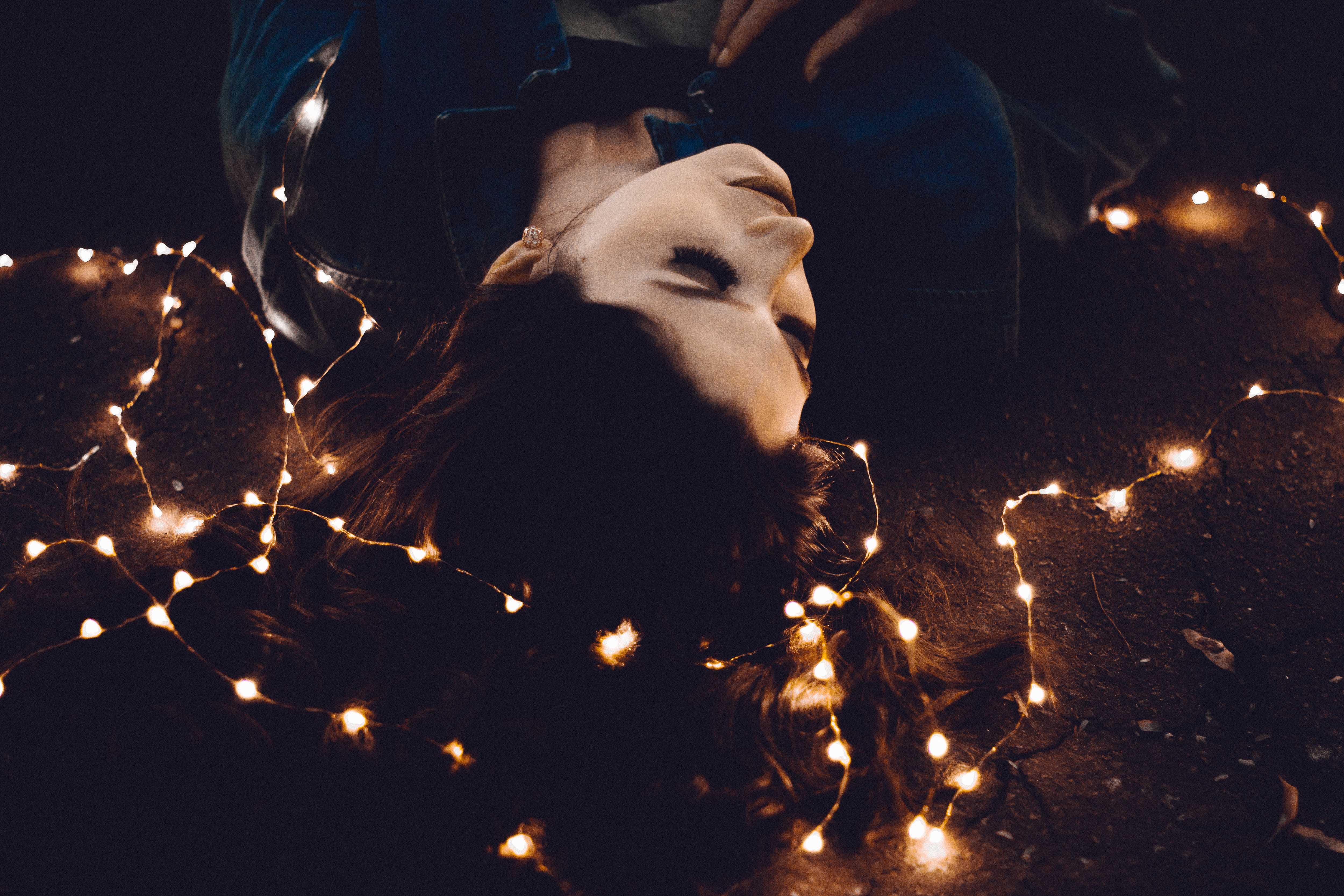 Woman lying down with fairy lights HD Wallpaper