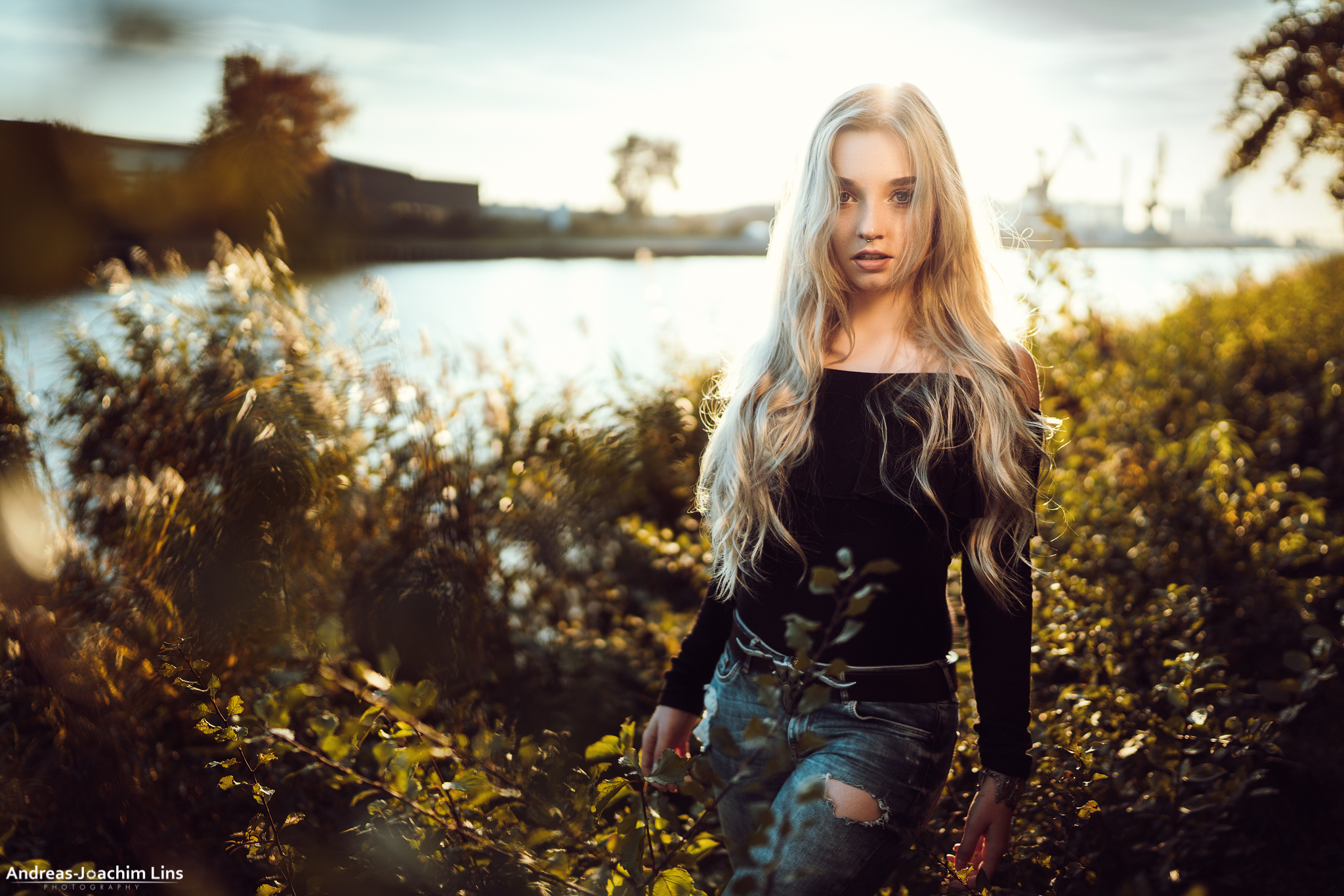 Woman with blonde hair and torn jeans by the river HD Wallpaper