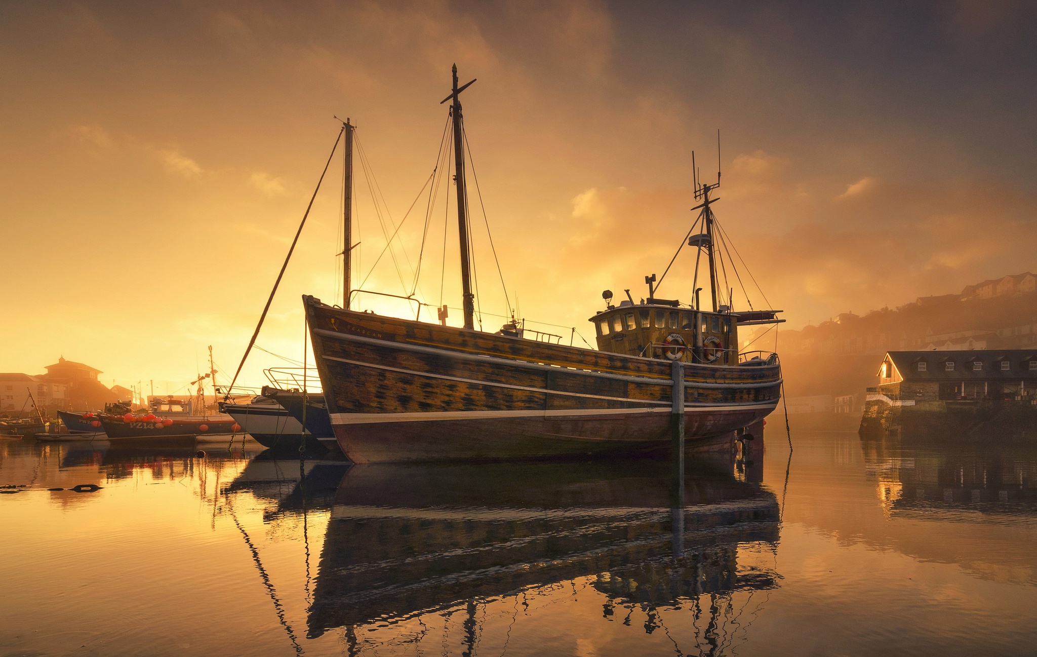 Fishing boat docked in harbor at sunset with reflection HD Wallpaper