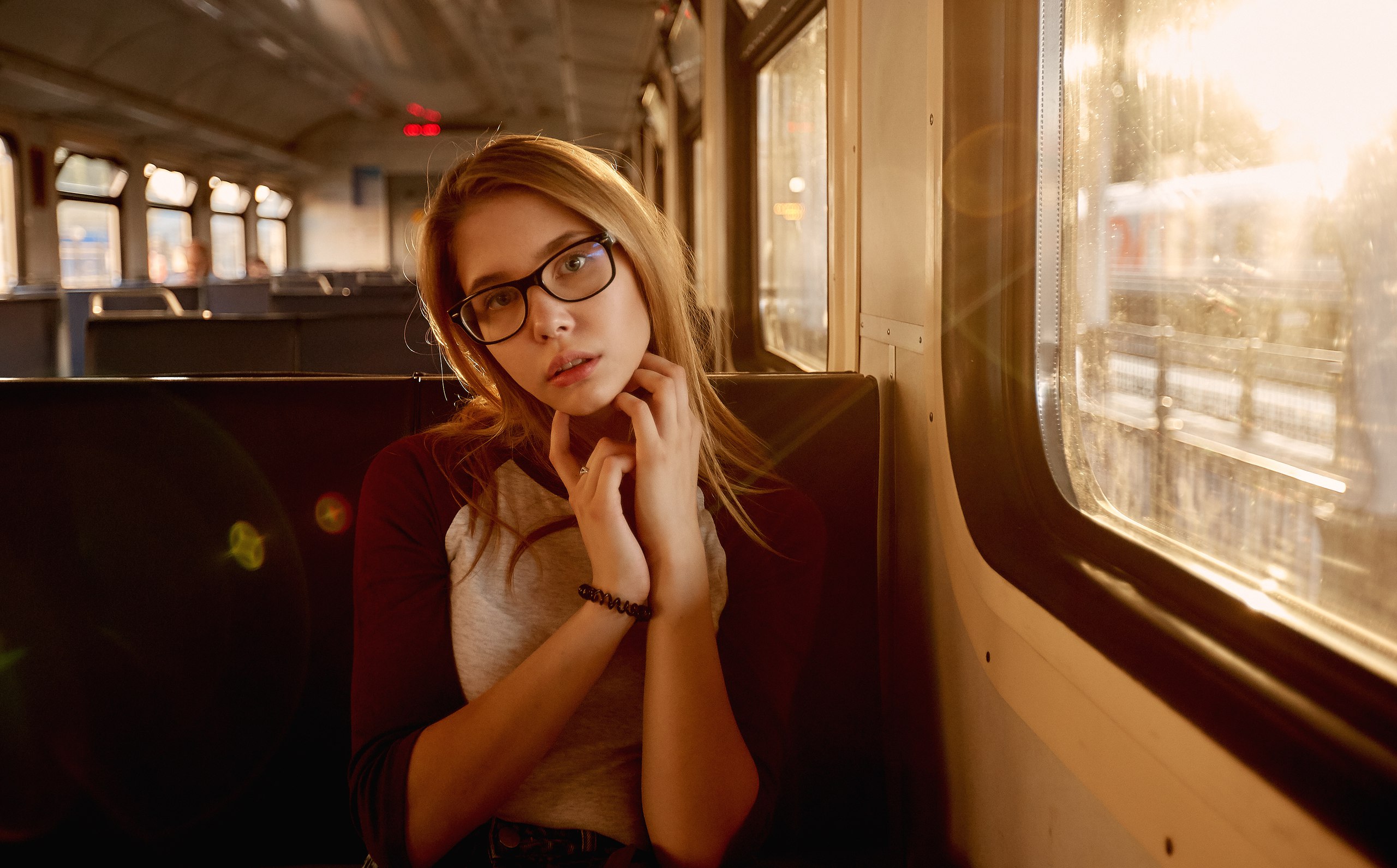 Young woman with glasses on a train HD Wallpaper