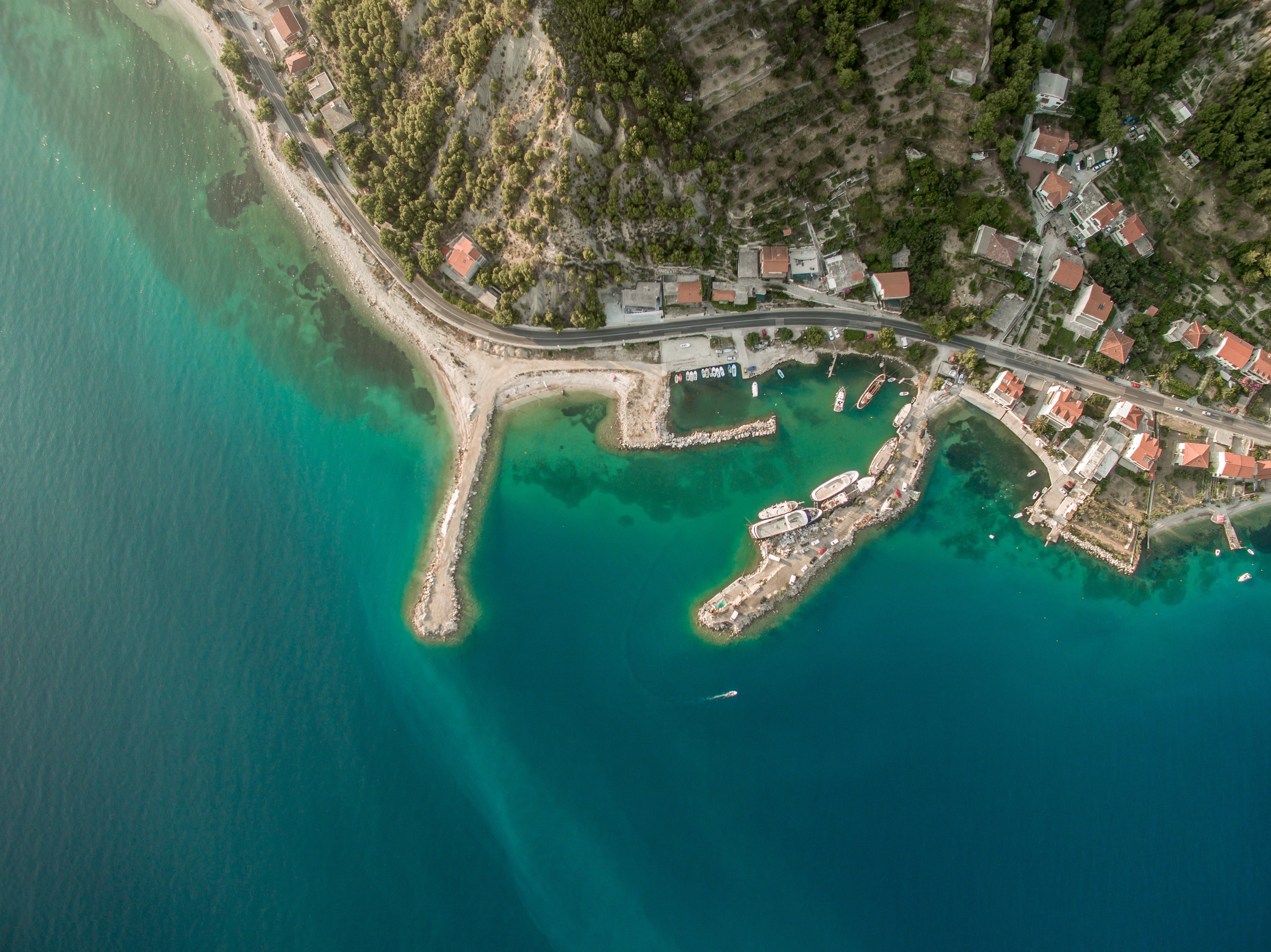 Aerial view of a coastal town with a harbor and boats HD Wallpaper