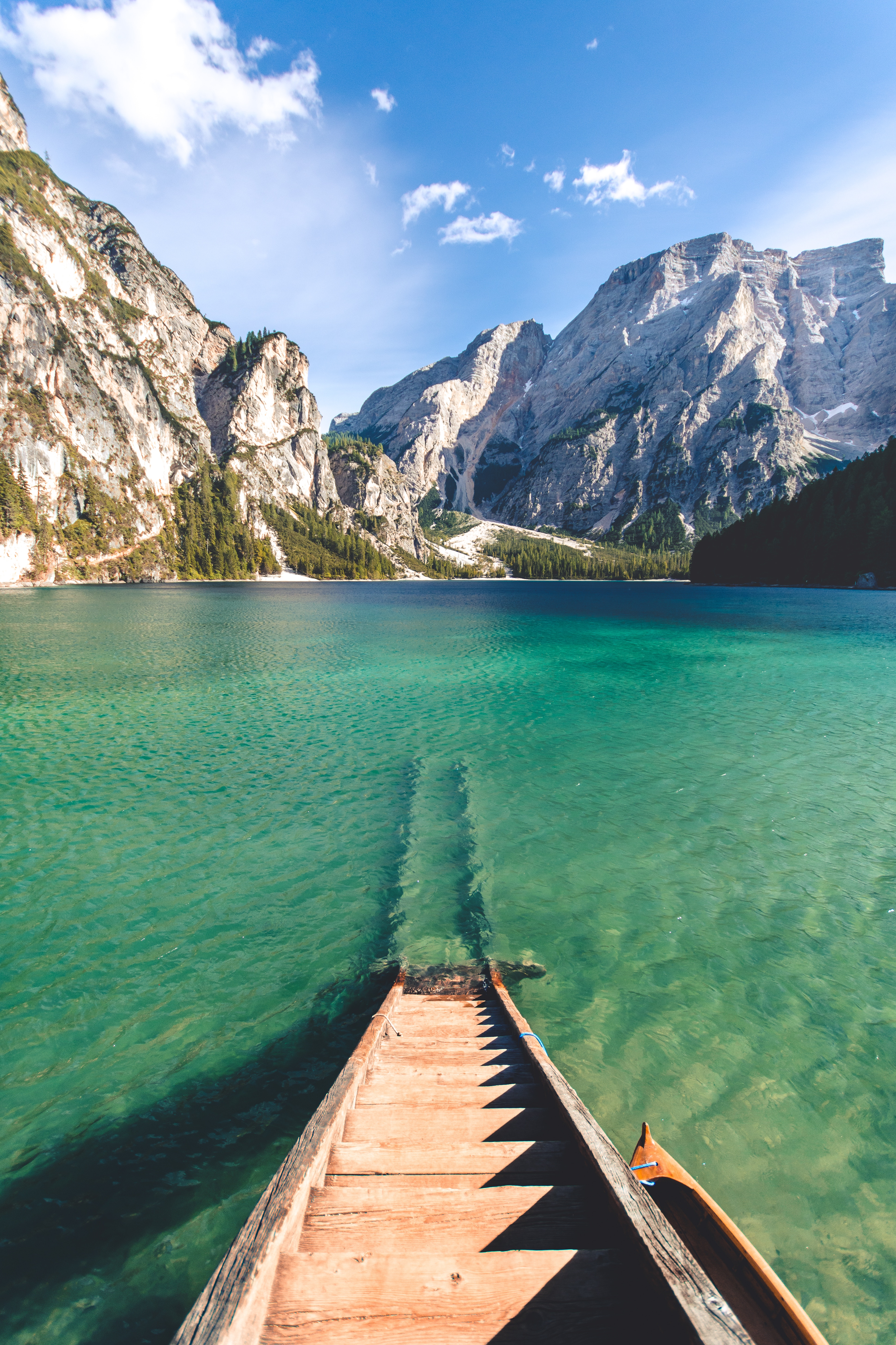 Wooden boat on a clear turquoise lake with mountains HD Wallpaper
