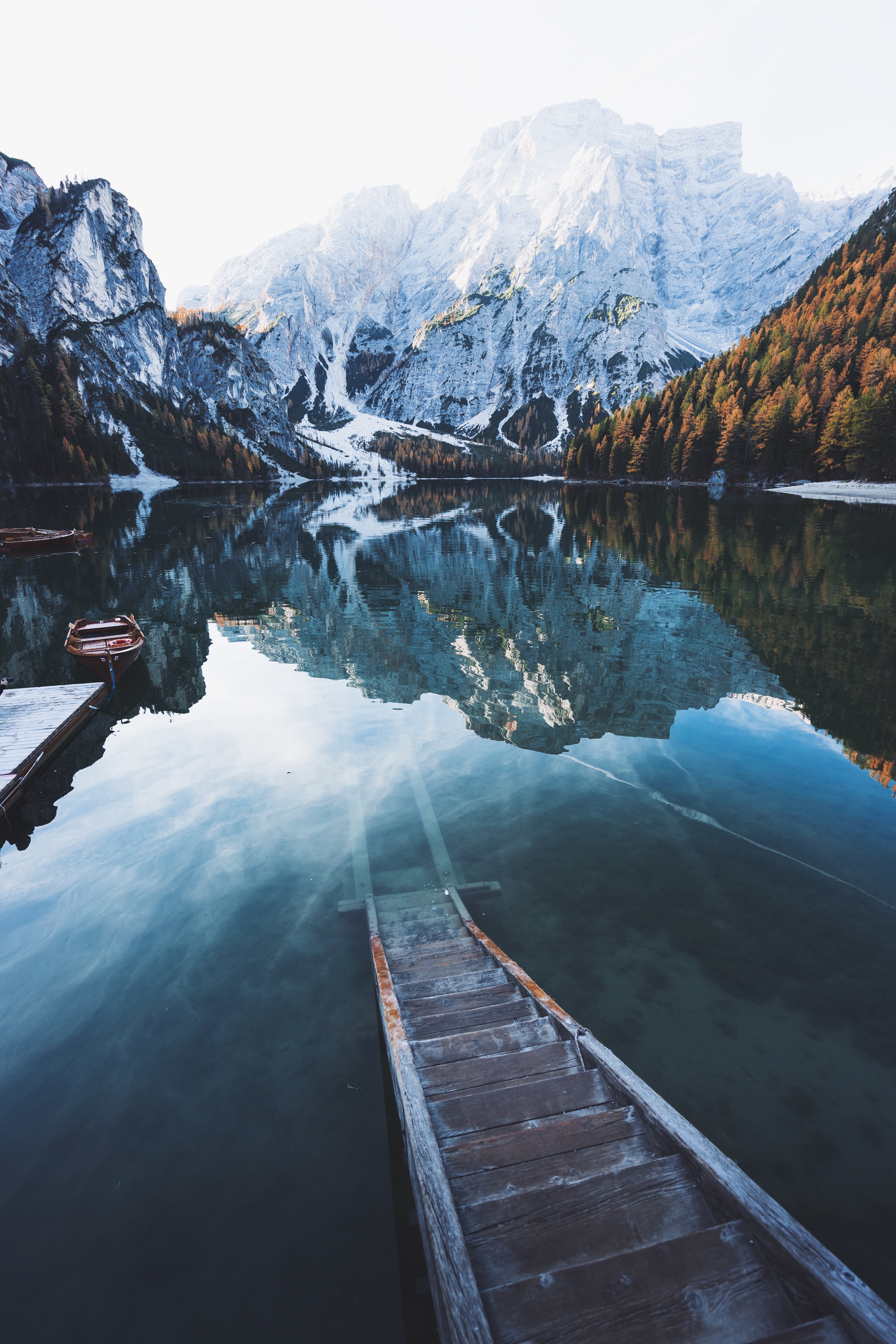 Wooden stairs leading into a mountain lake with reflections HD Wallpaper