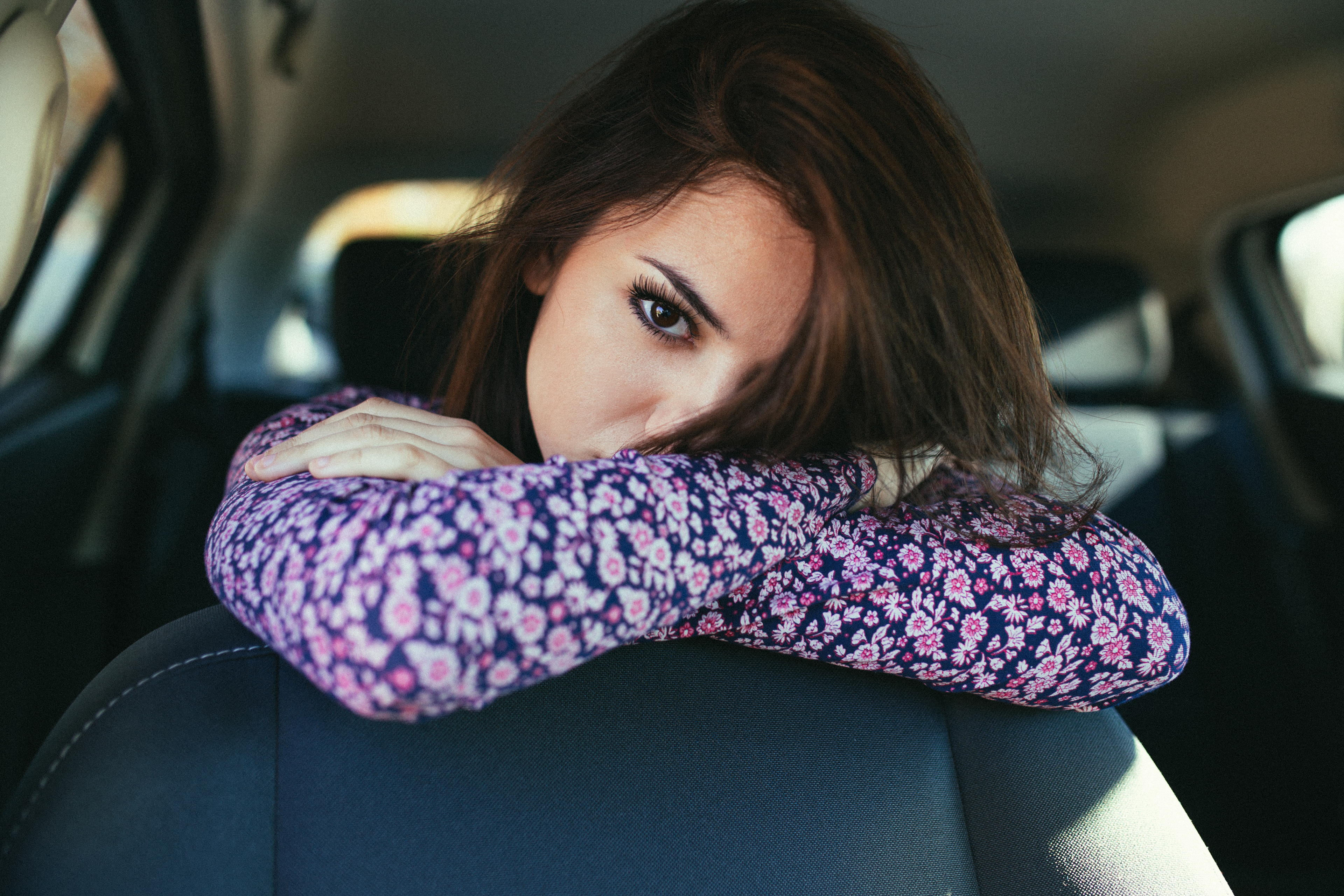 Woman with dark hair in a car HD Wallpaper