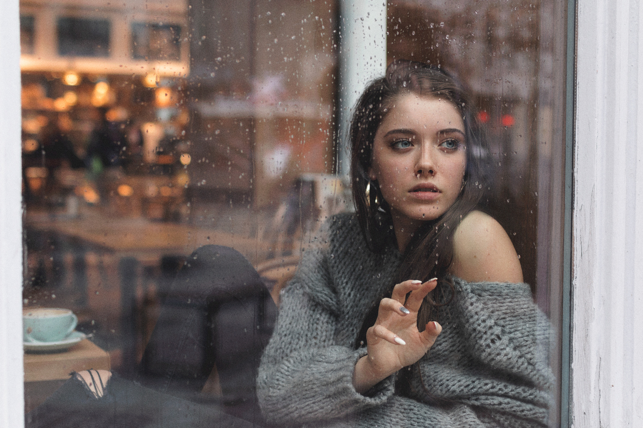 Polish women, torn jeans, looking into the distance, sweater, hoop earrings, portrait, rain, women, long hair, Kuba Brencz, face, brunette, Dagmara Podolak, grey sweater, blue eyes, window HD Wallpaper
