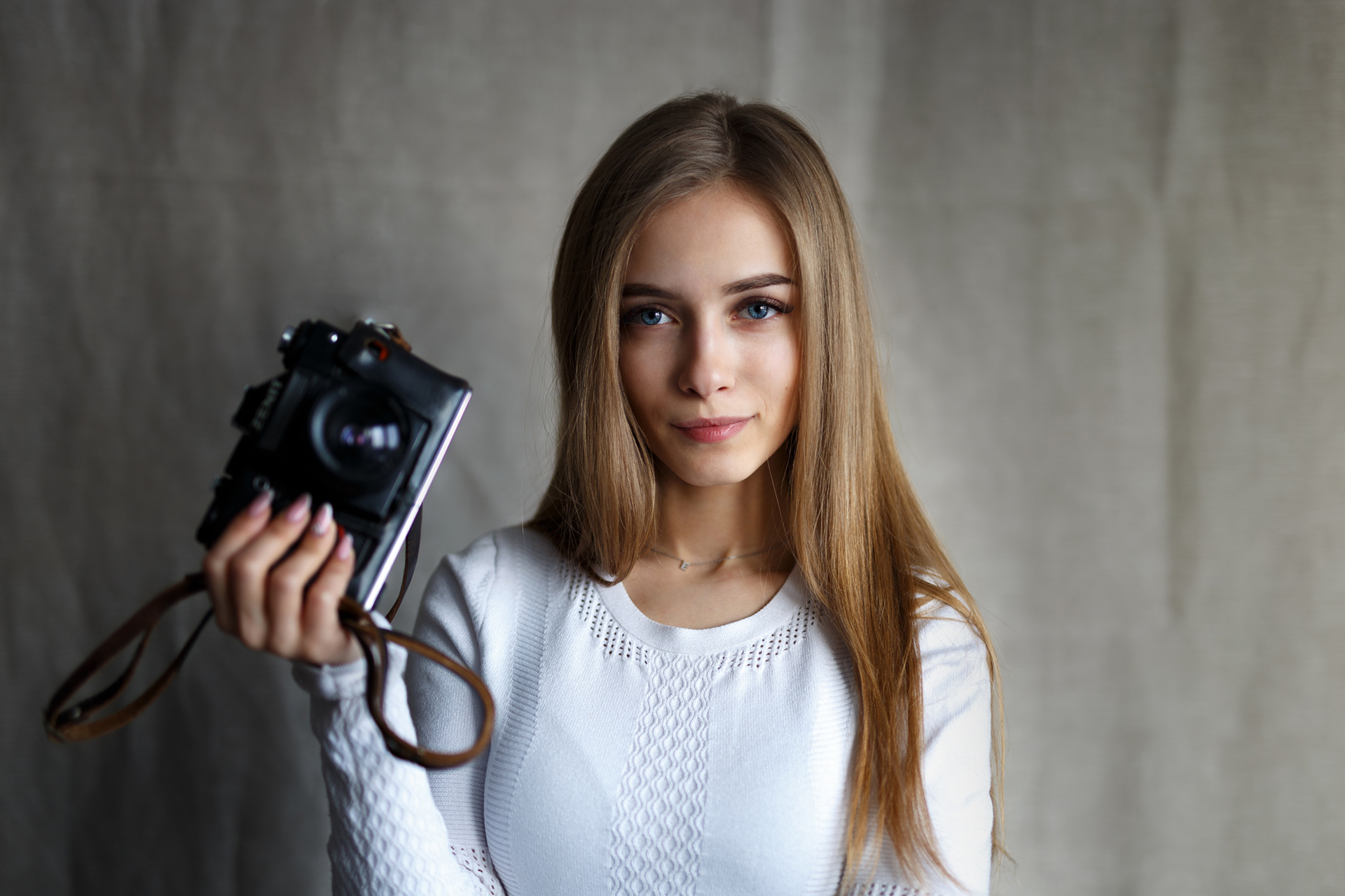 Woman with blonde hair holding a camera HD Wallpaper