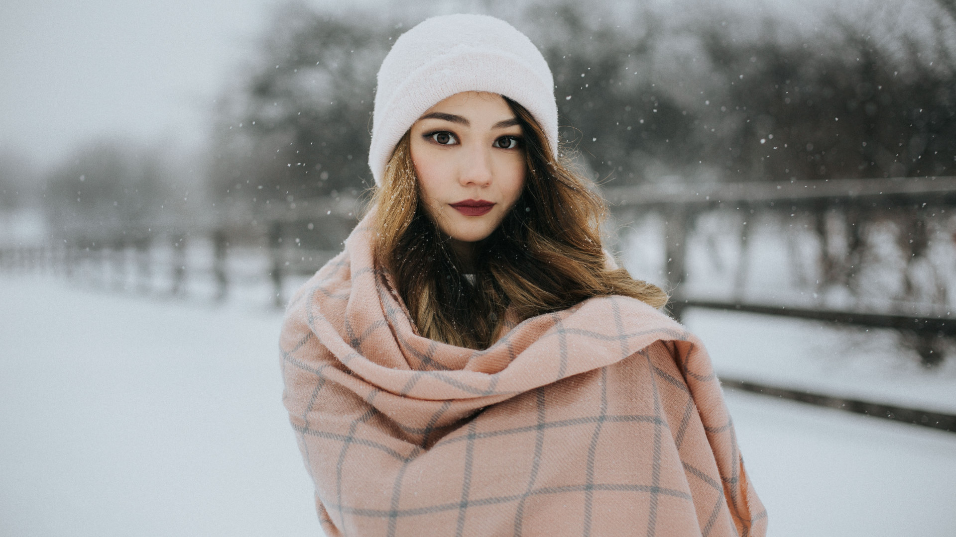 Woman in snow wearing a white hat and pink scarf HD Wallpaper