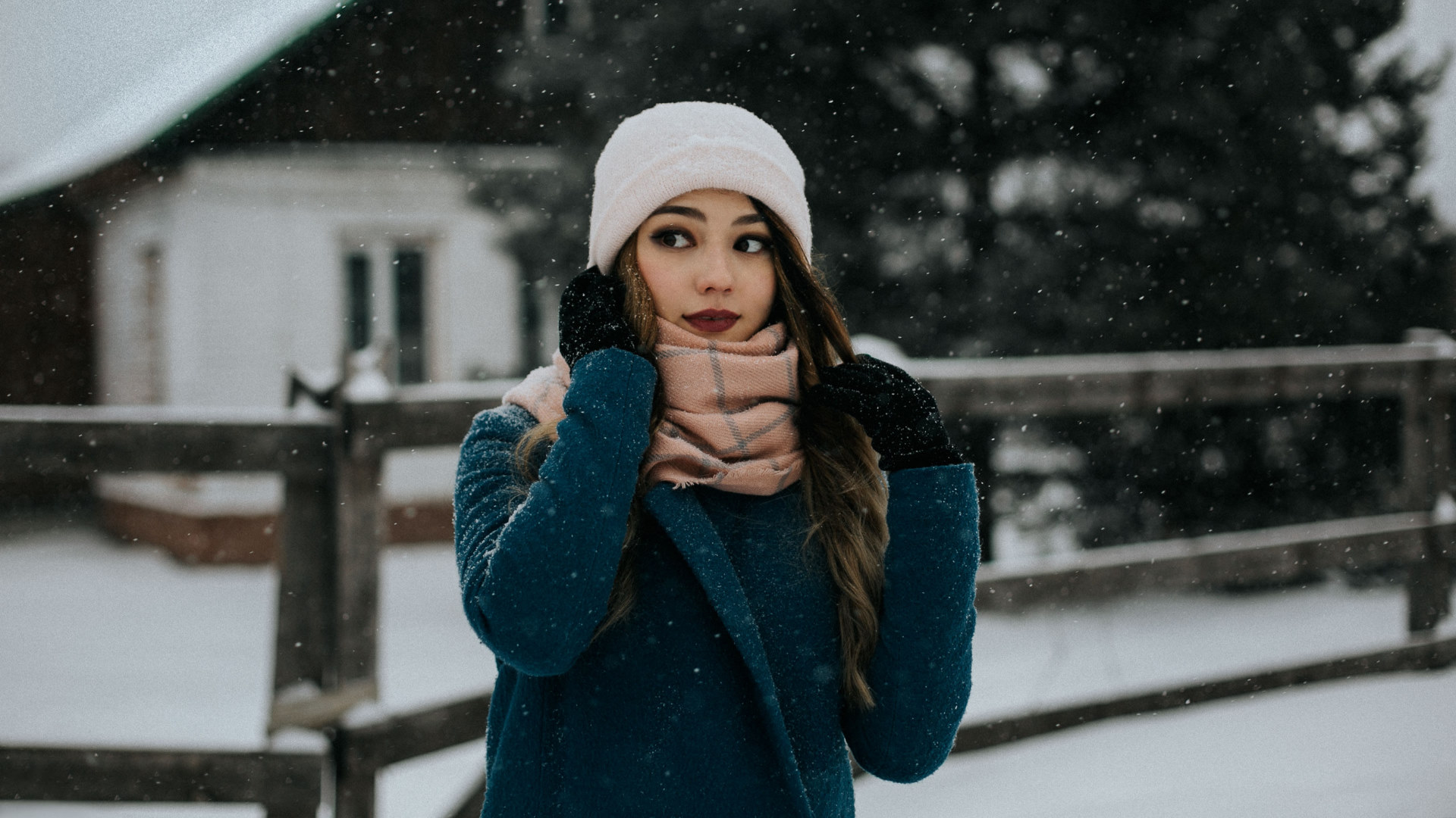 Woman in a blue coat and white hat in the snow HD Wallpaper