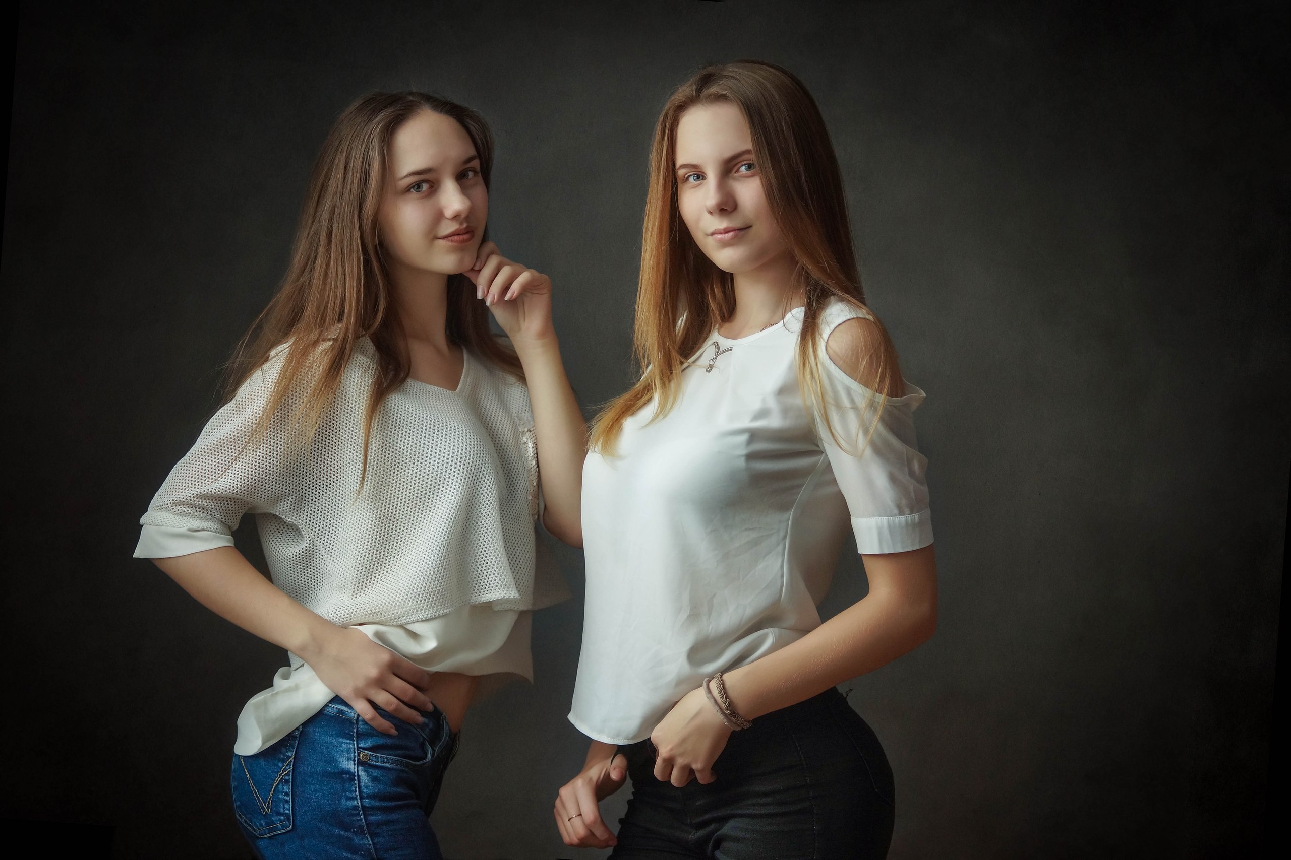 Two young women posing against a dark background HD Wallpaper