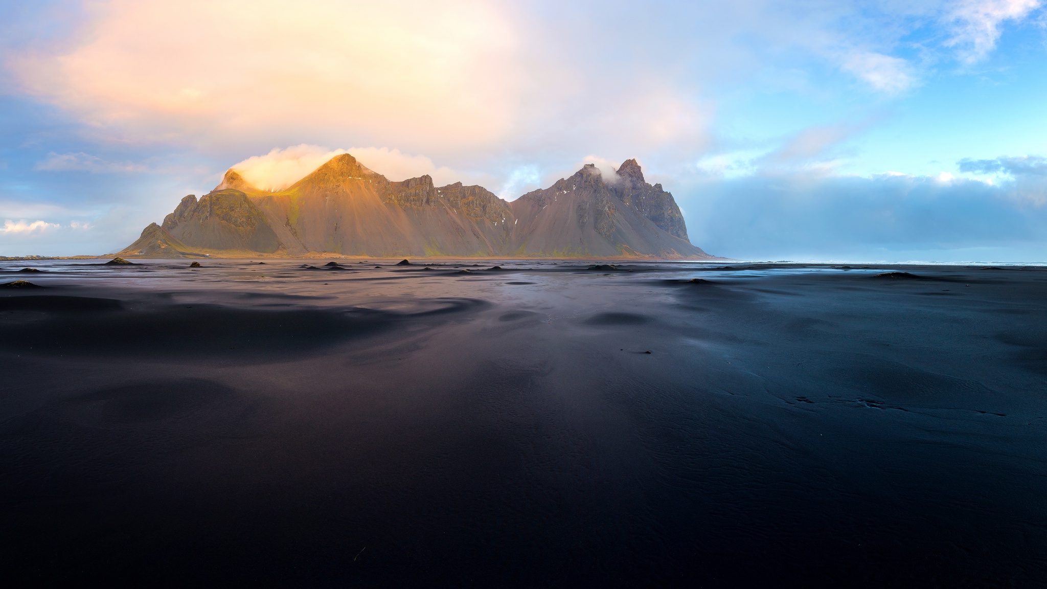 Mountain range on black sand beach in Iceland HD Wallpaper