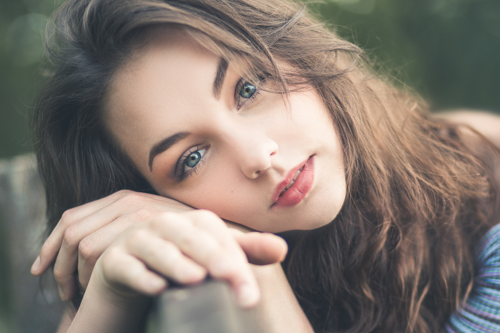 Woman with blue eyes resting her head on her hand HD Wallpaper