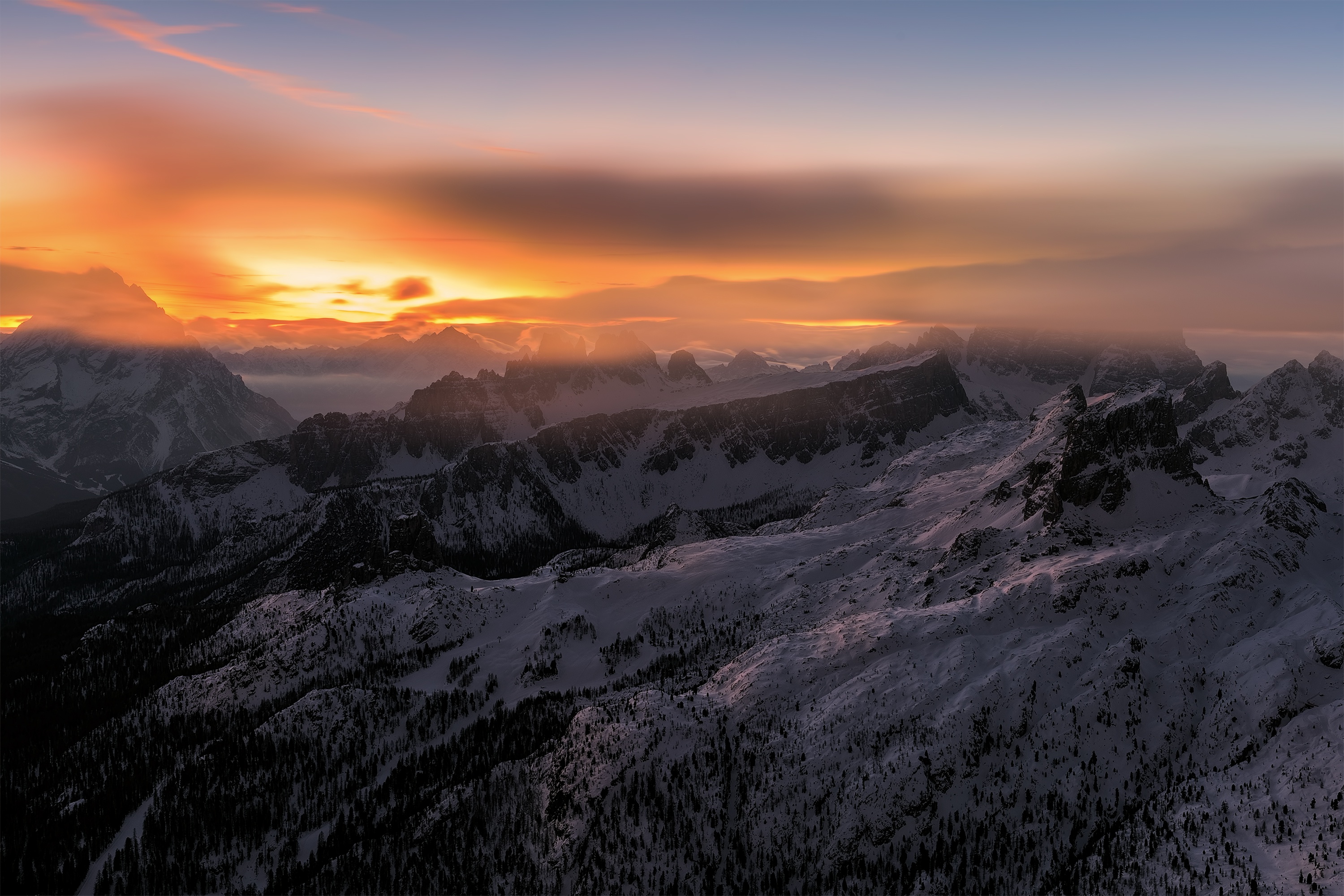 Snowy mountains at sunset with orange sky HD Wallpaper