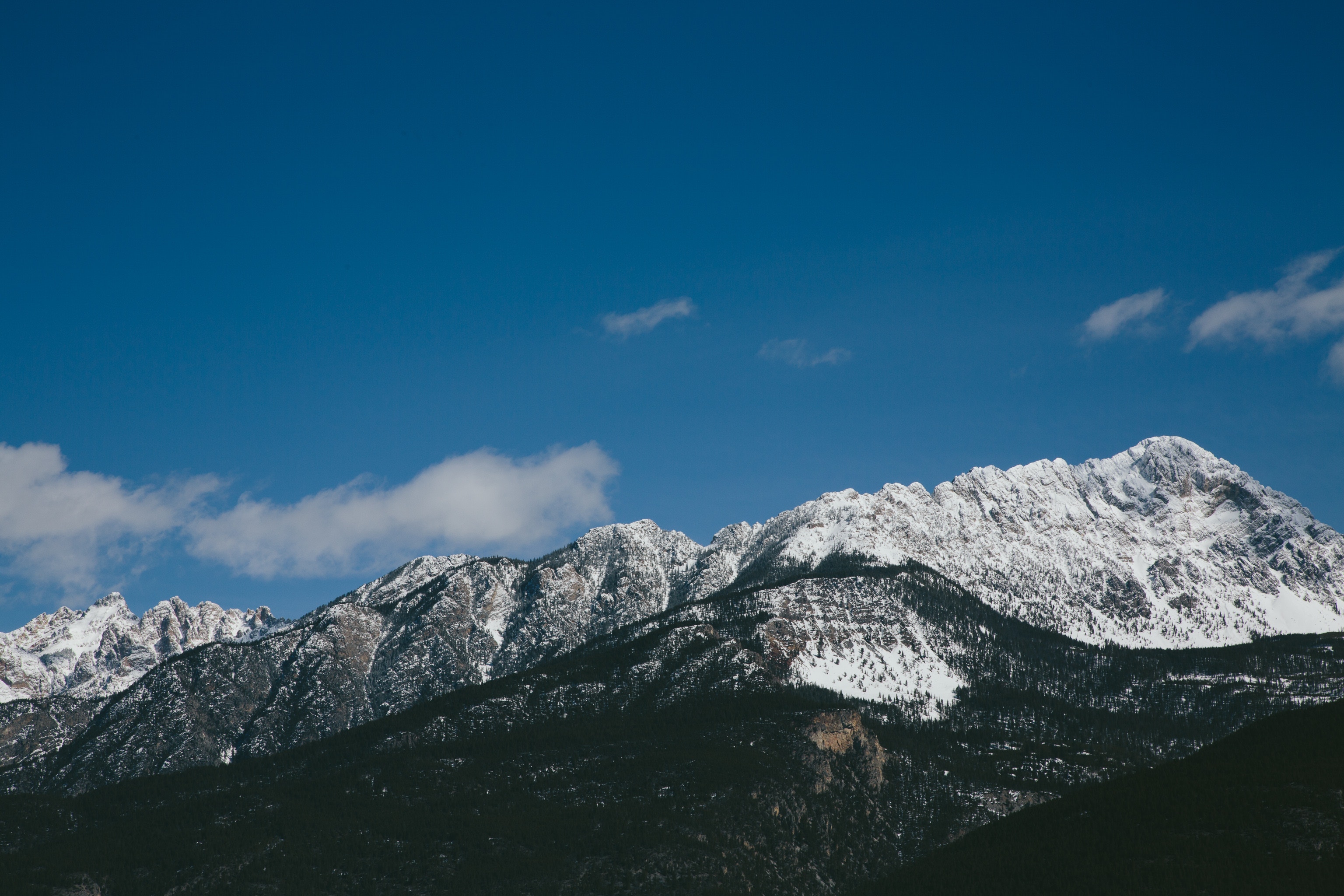 Snowy mountain range under a blue sky with clouds HD Wallpaper
