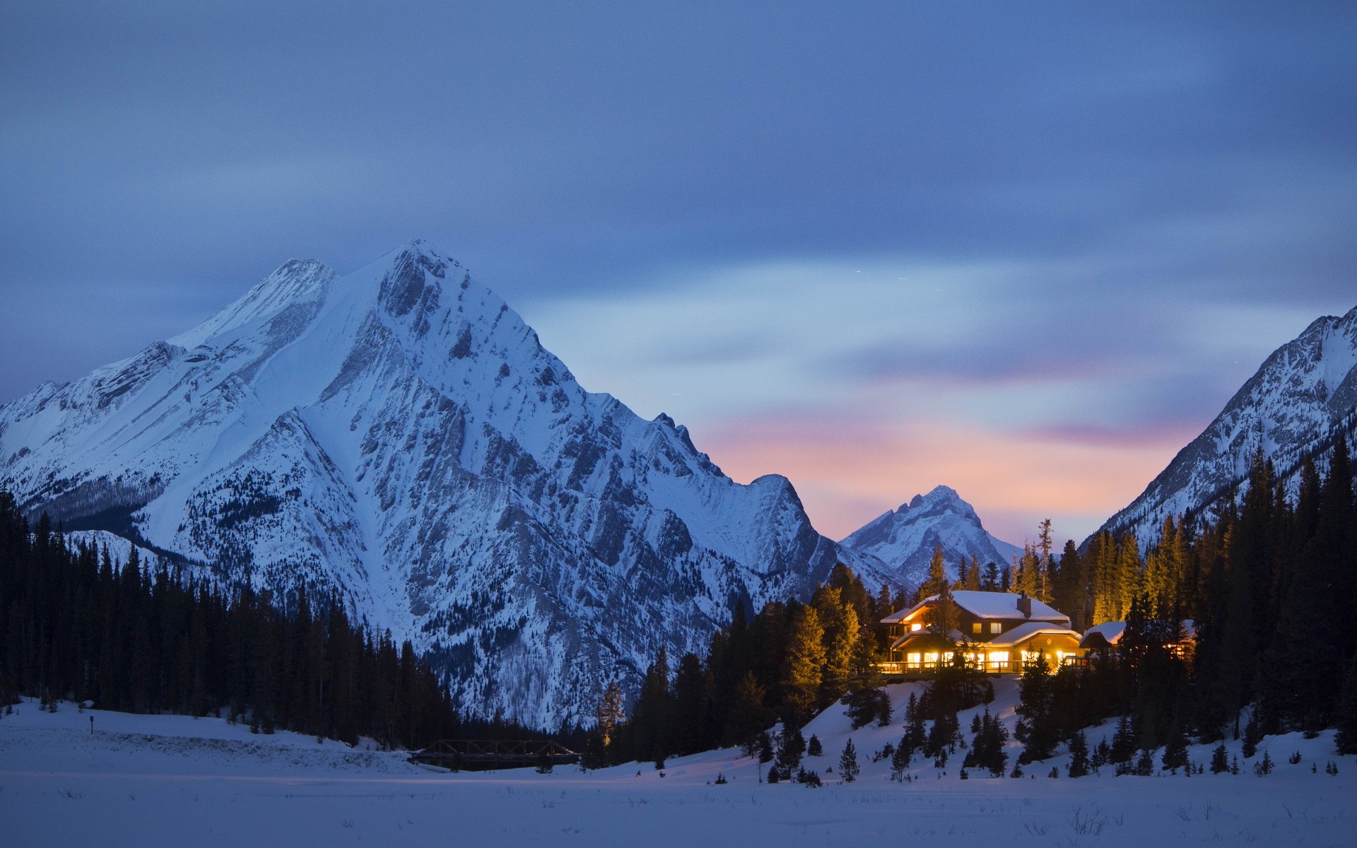 Snowy mountains and a lodge at dusk HD Wallpaper